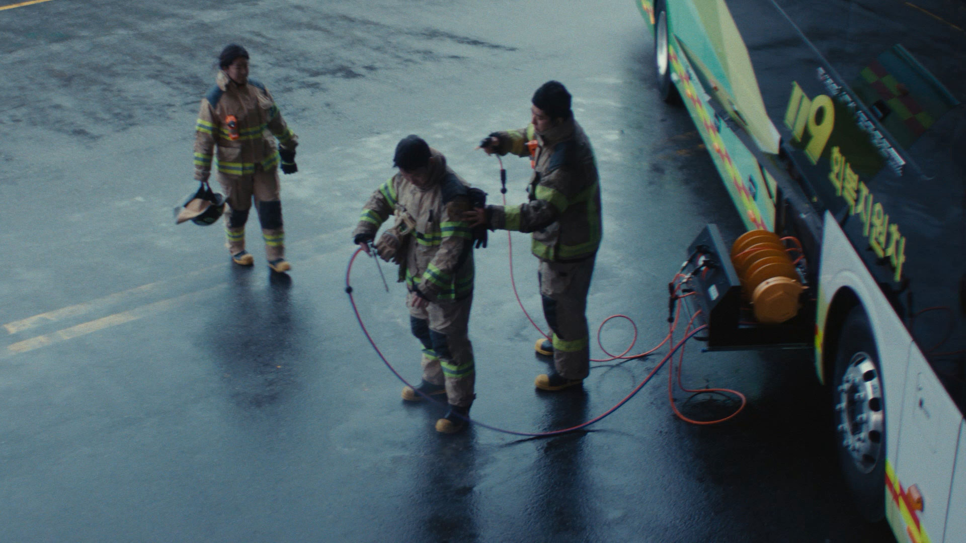 회복지원 수소전기버스 외부에 장착된 고압 에어건과 워터건을 이용해 화재 진압 현장에서 묻은 구조 장비의 오염 물질을 제거하는 소방관의 모습-이미지슬라이드