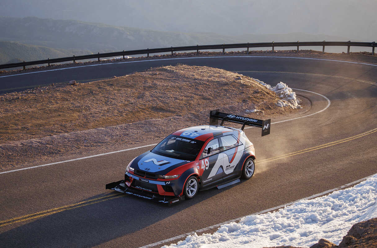 코너를 돌아 속도를 높이며 주행하는 차량의 모습