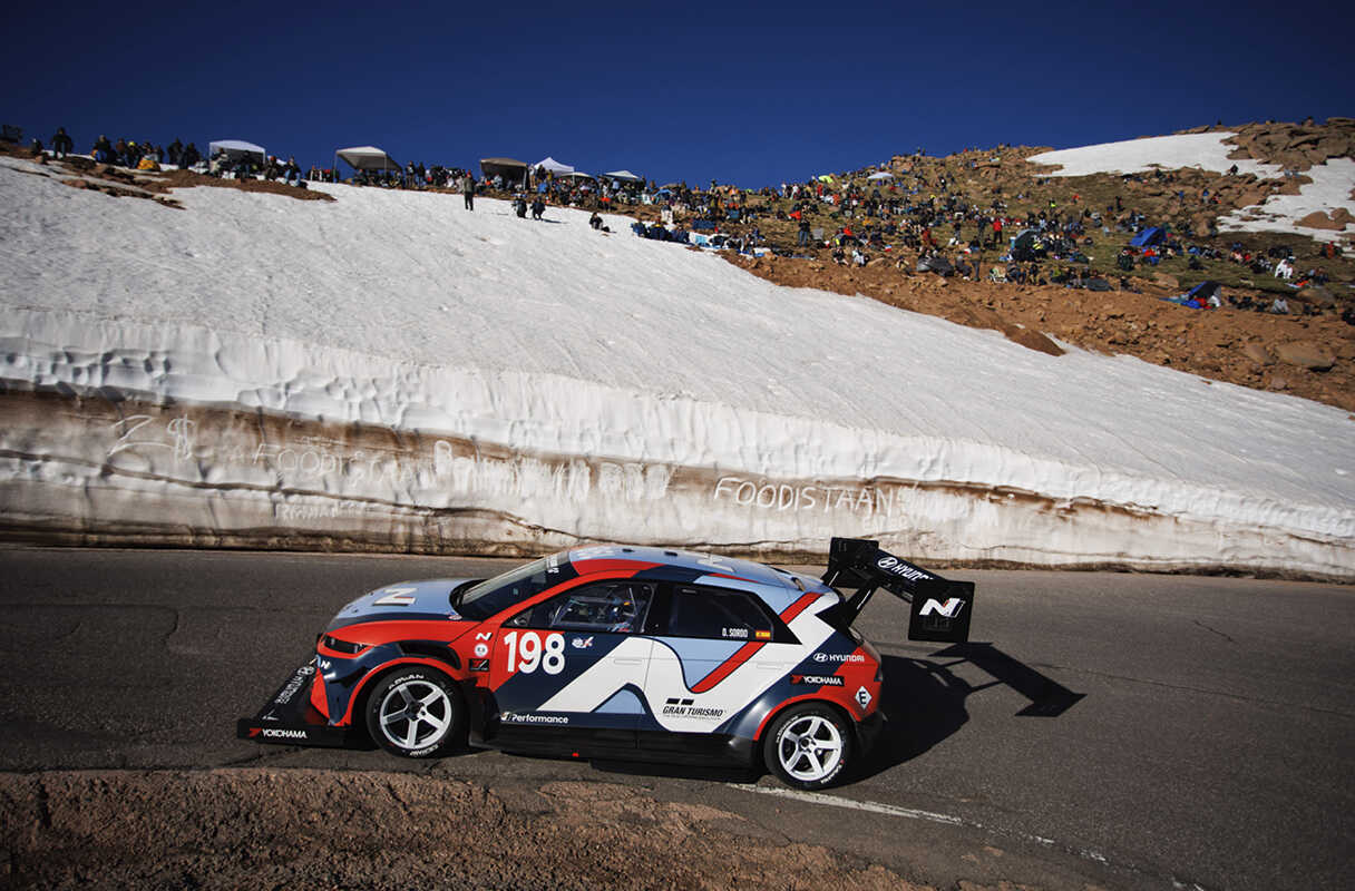 Side view of vehicles speeding along the Pikes Peak course