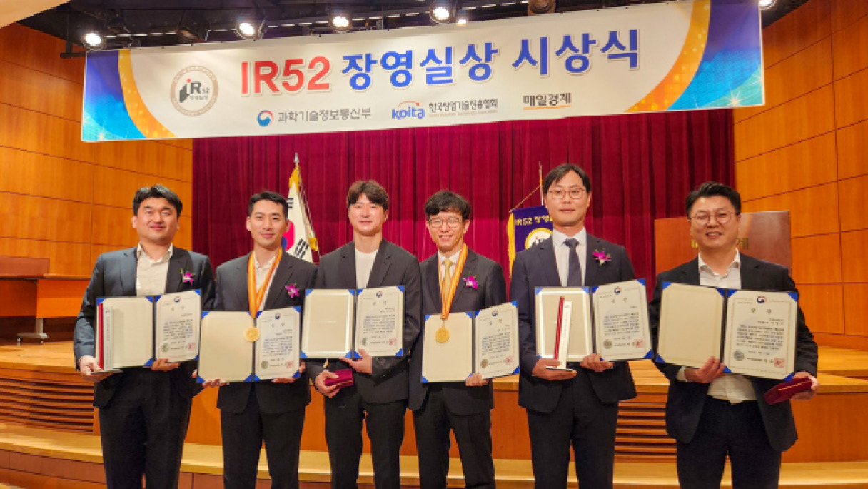 상을 받고 함께 사진을 찍는 사람들의 모습