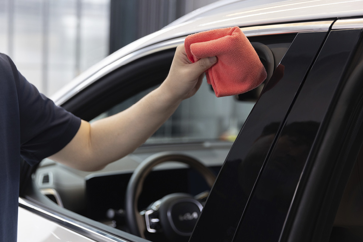 차량 창틀을 타월로 닦는 모습