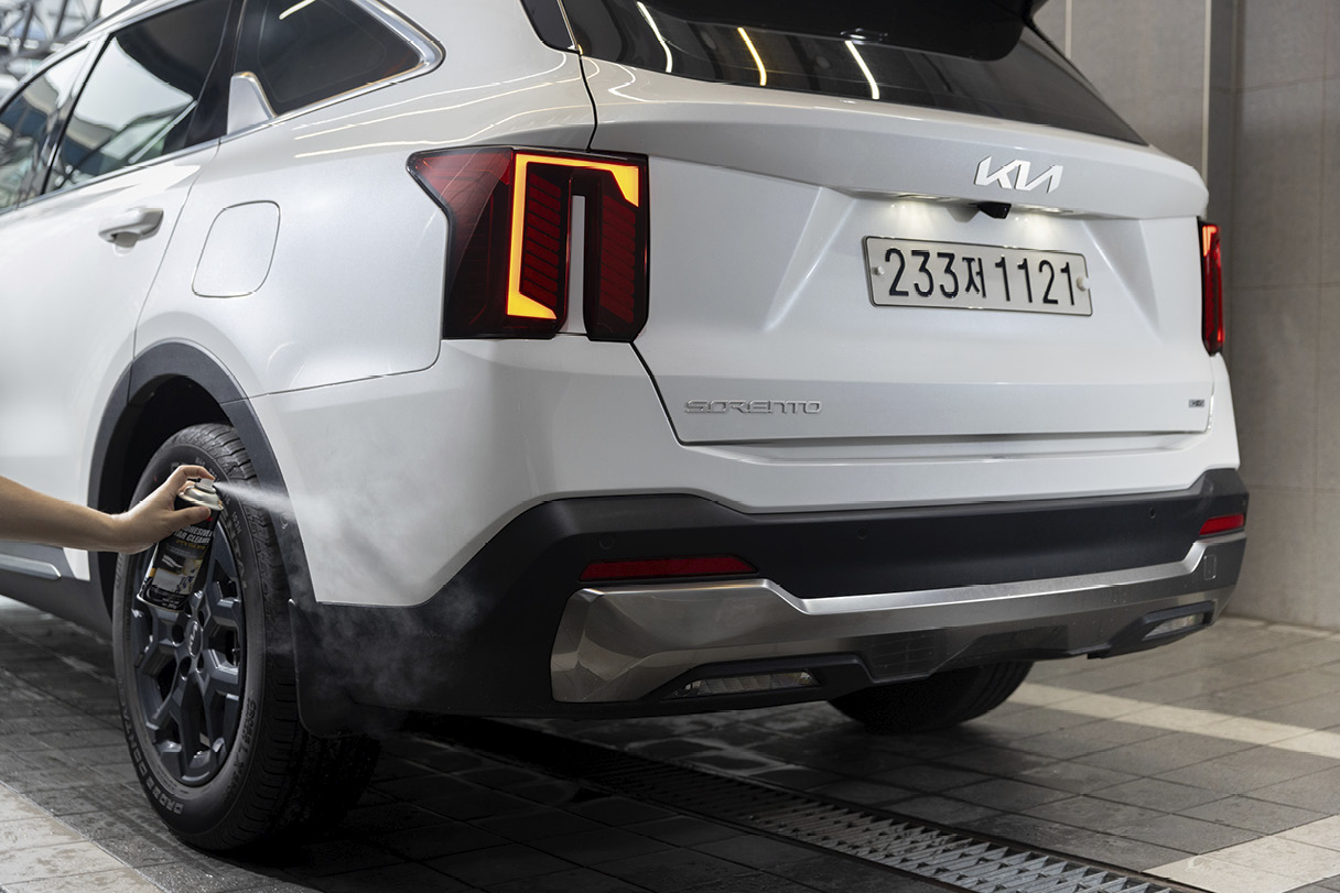 차량 뒤쪽 펜더에 스프레이를 뿌리는 모습