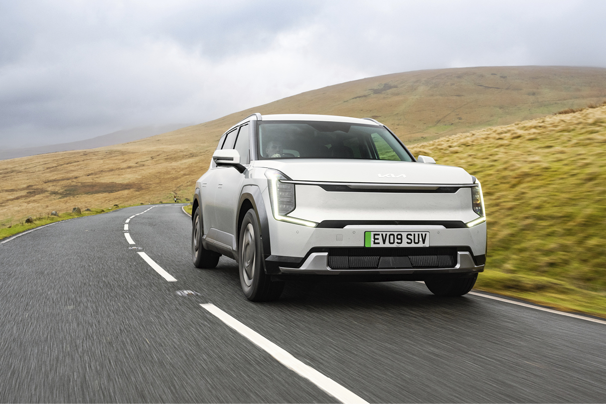 숲길을 주행하는 은색 SUV 전측면 모습