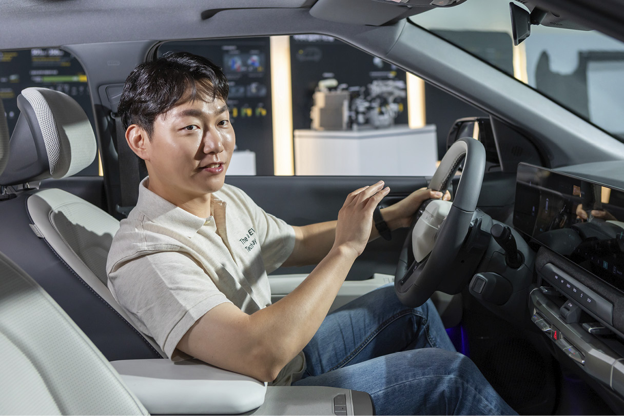 성인 남성이 운전석에 앉아 설명하는 모습