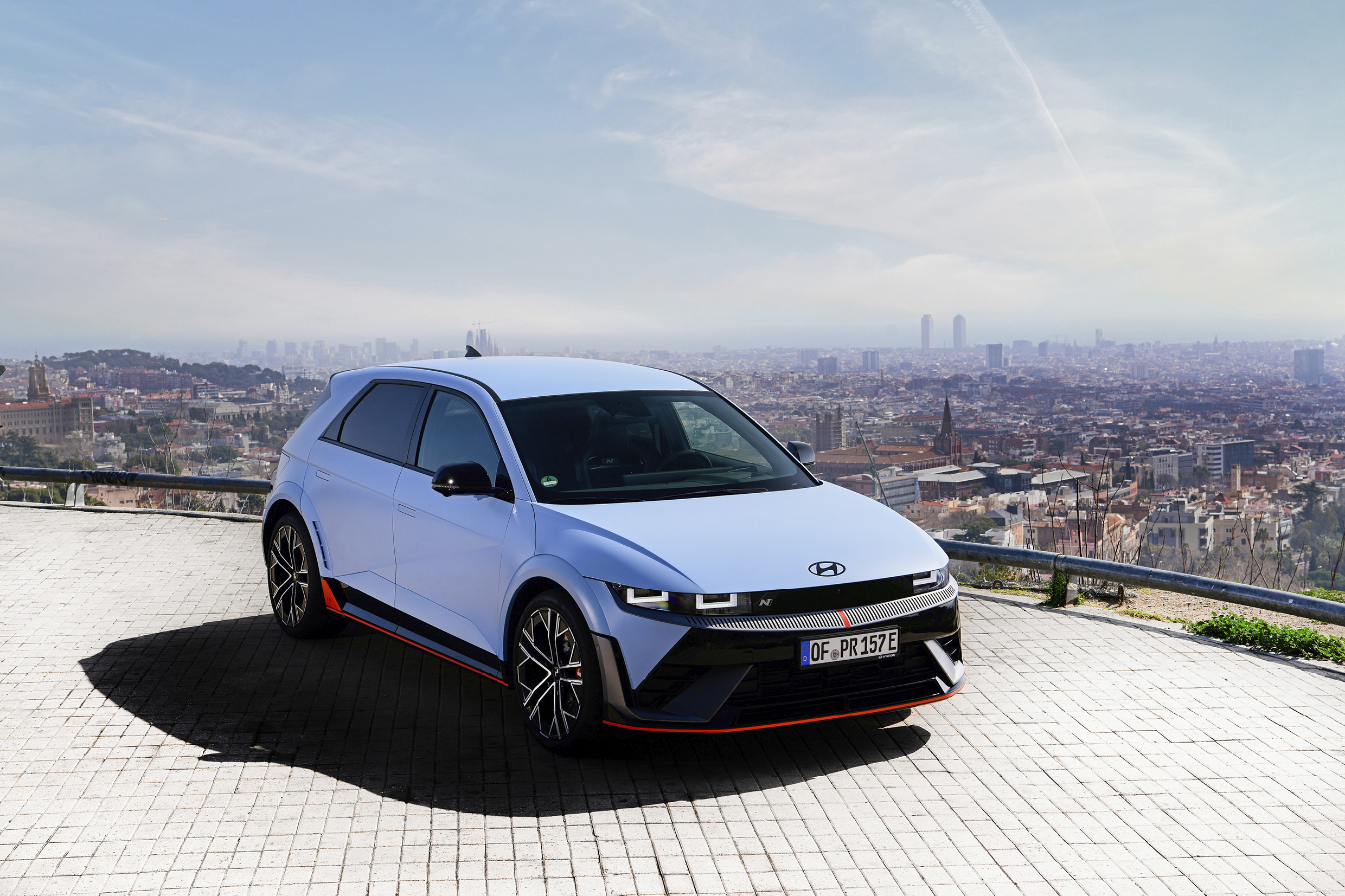 언덕 위에 정차한 하늘색 해치백 전측면 모습