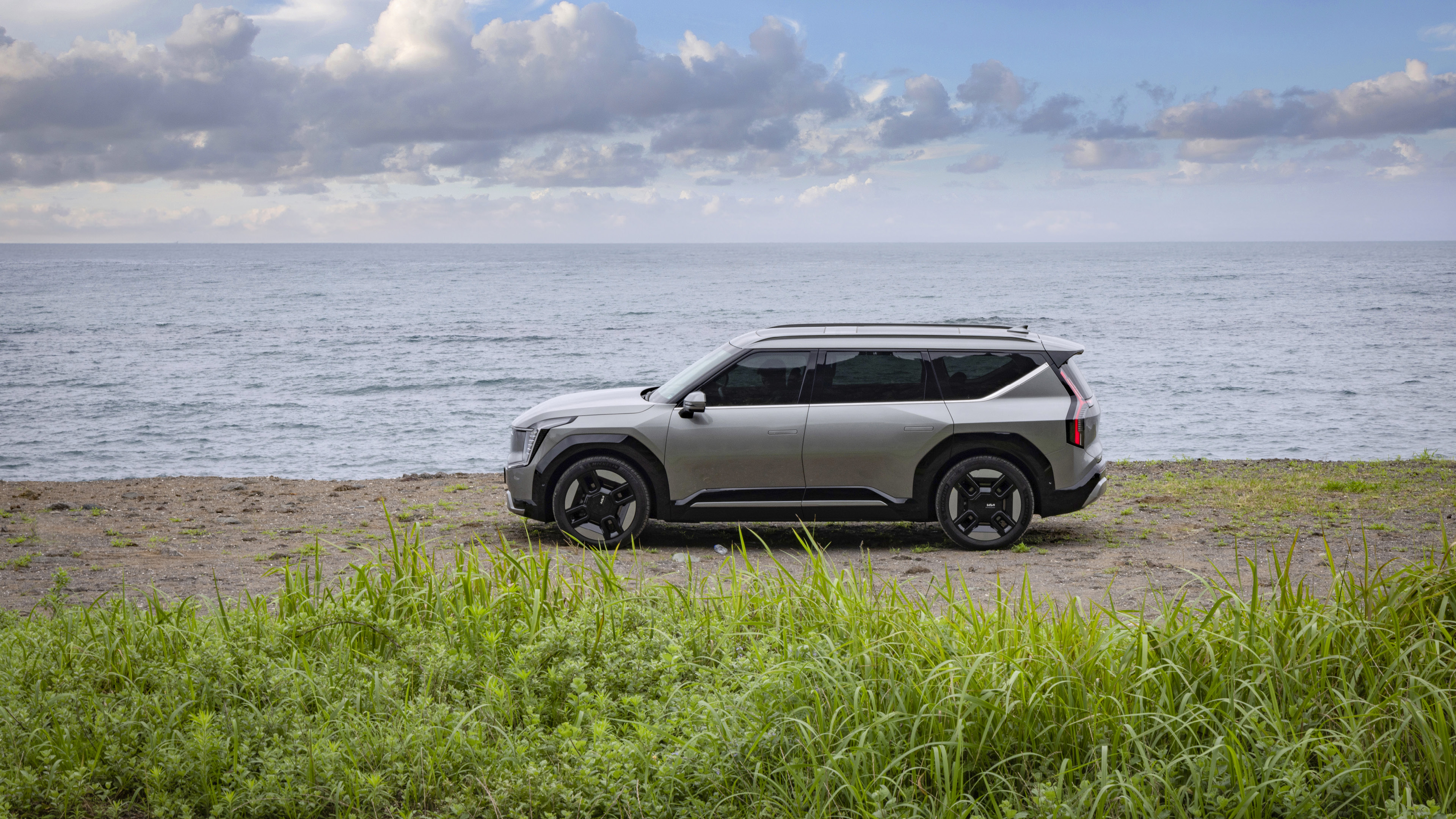 회색 SUV가 바닷가에 정차한 측면 모습