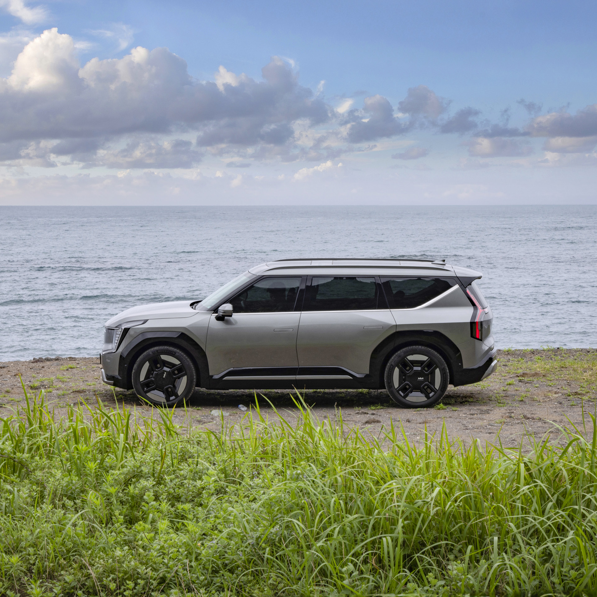 A side view of a gray SUV stopping by the sea