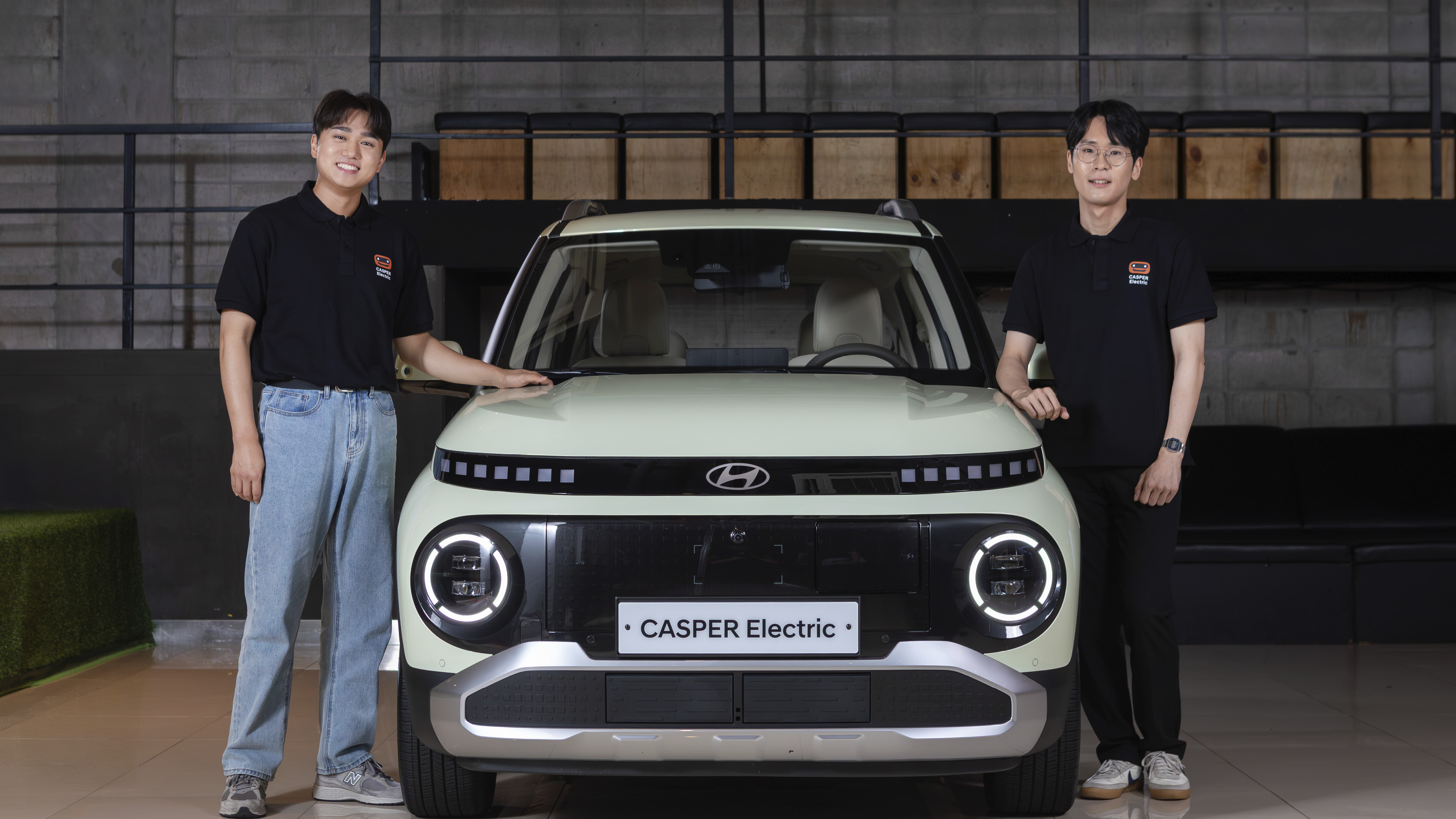 차량 양 옆에 서서 손을 올리고 있는 두 명의 남자