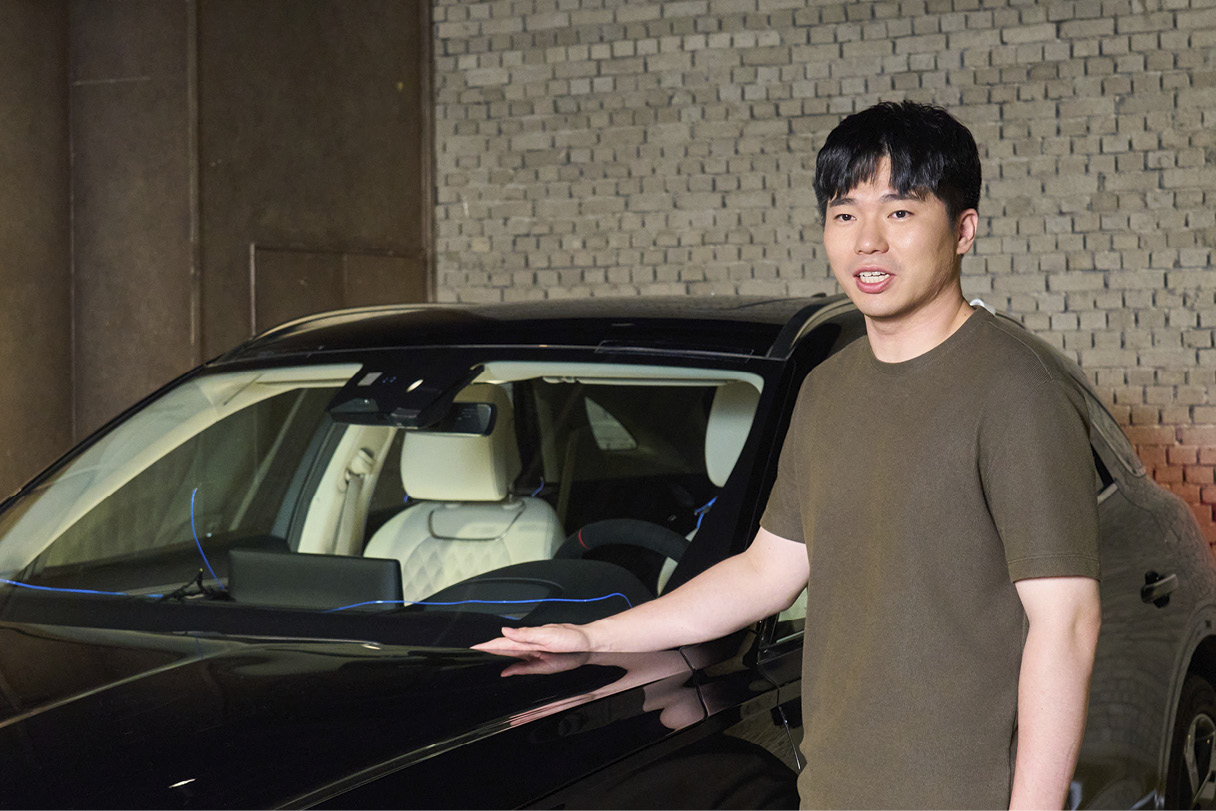 남성이 차량 옆에 서서 포즈를 취한 모습