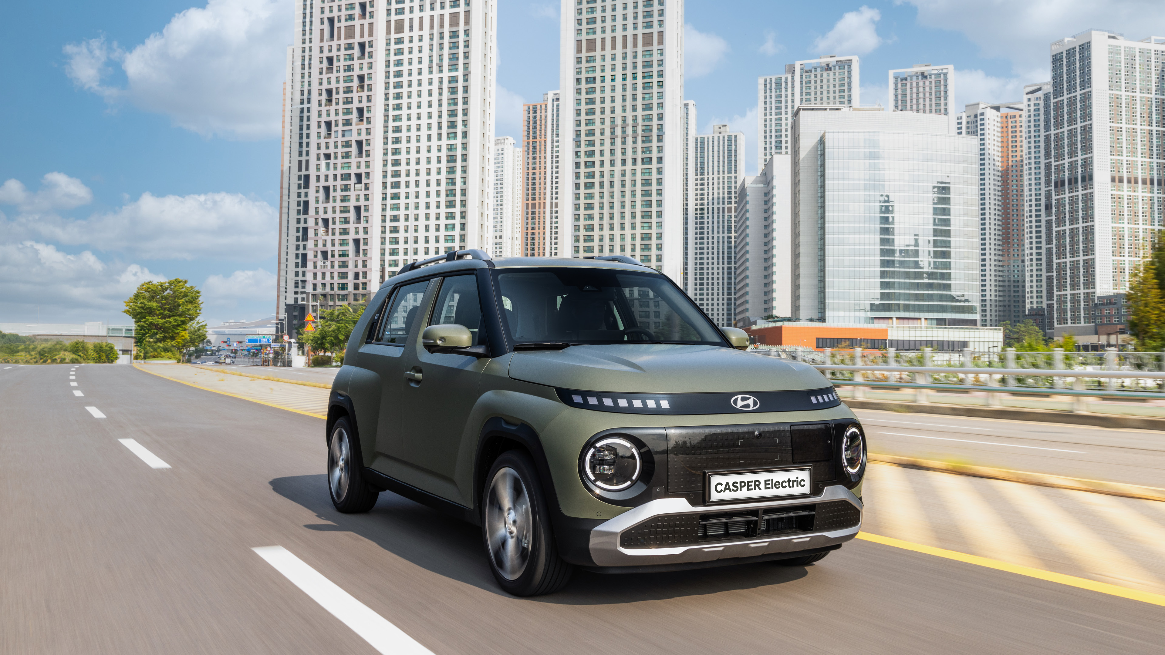 도시를 주행 중인 캐스퍼 일렉트릭 전측면 모습