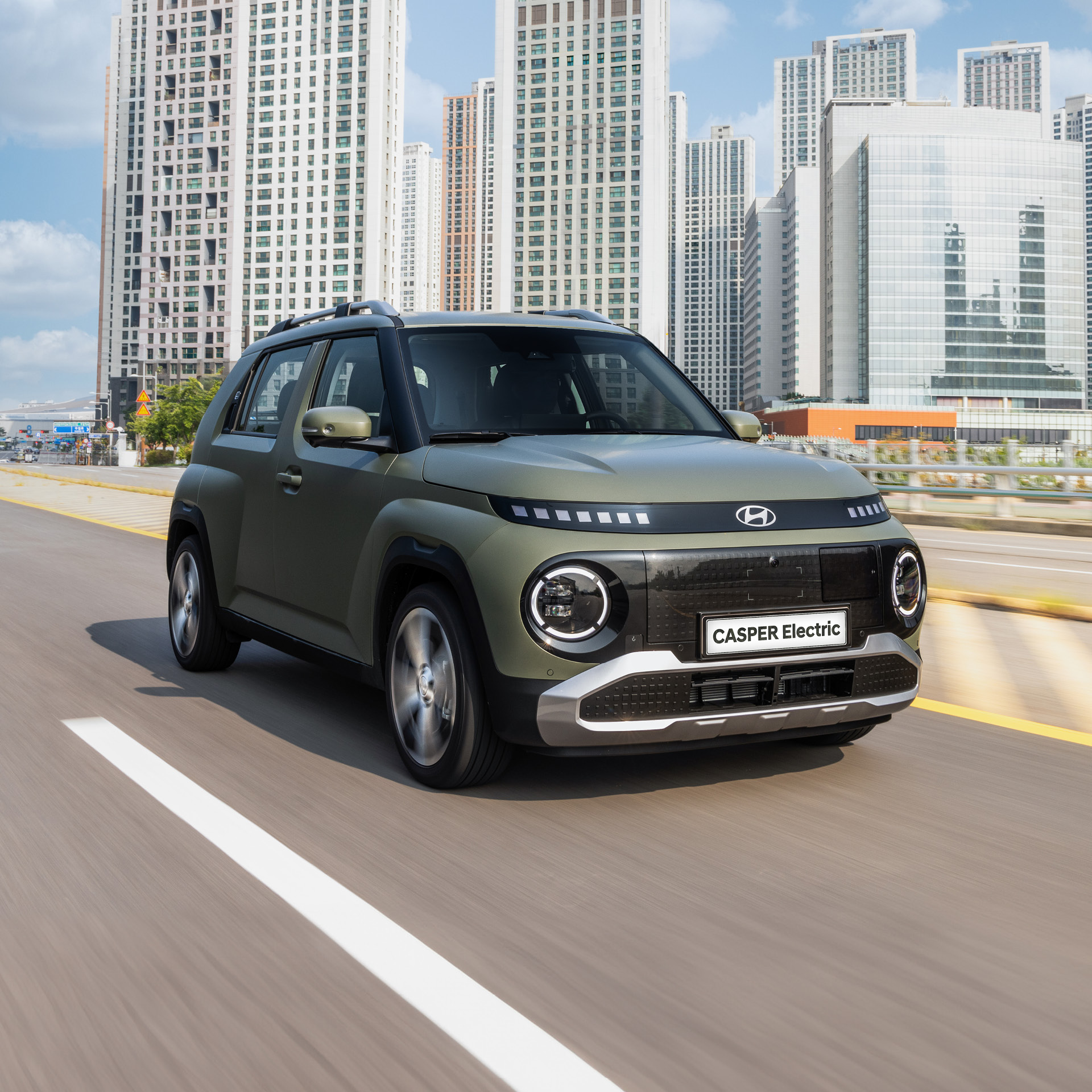 도시를 주행 중인 캐스퍼 일렉트릭 전측면 모습