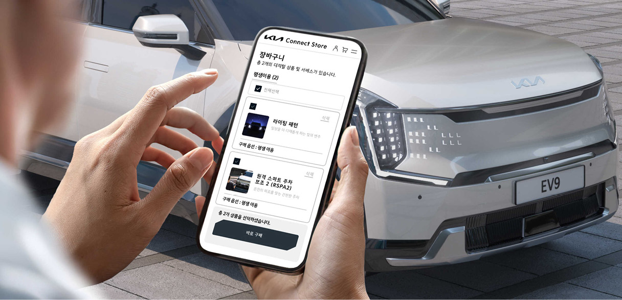 차량 앞에서 스마트폰으로 시스템을 설정하고 있는 사람의 모습