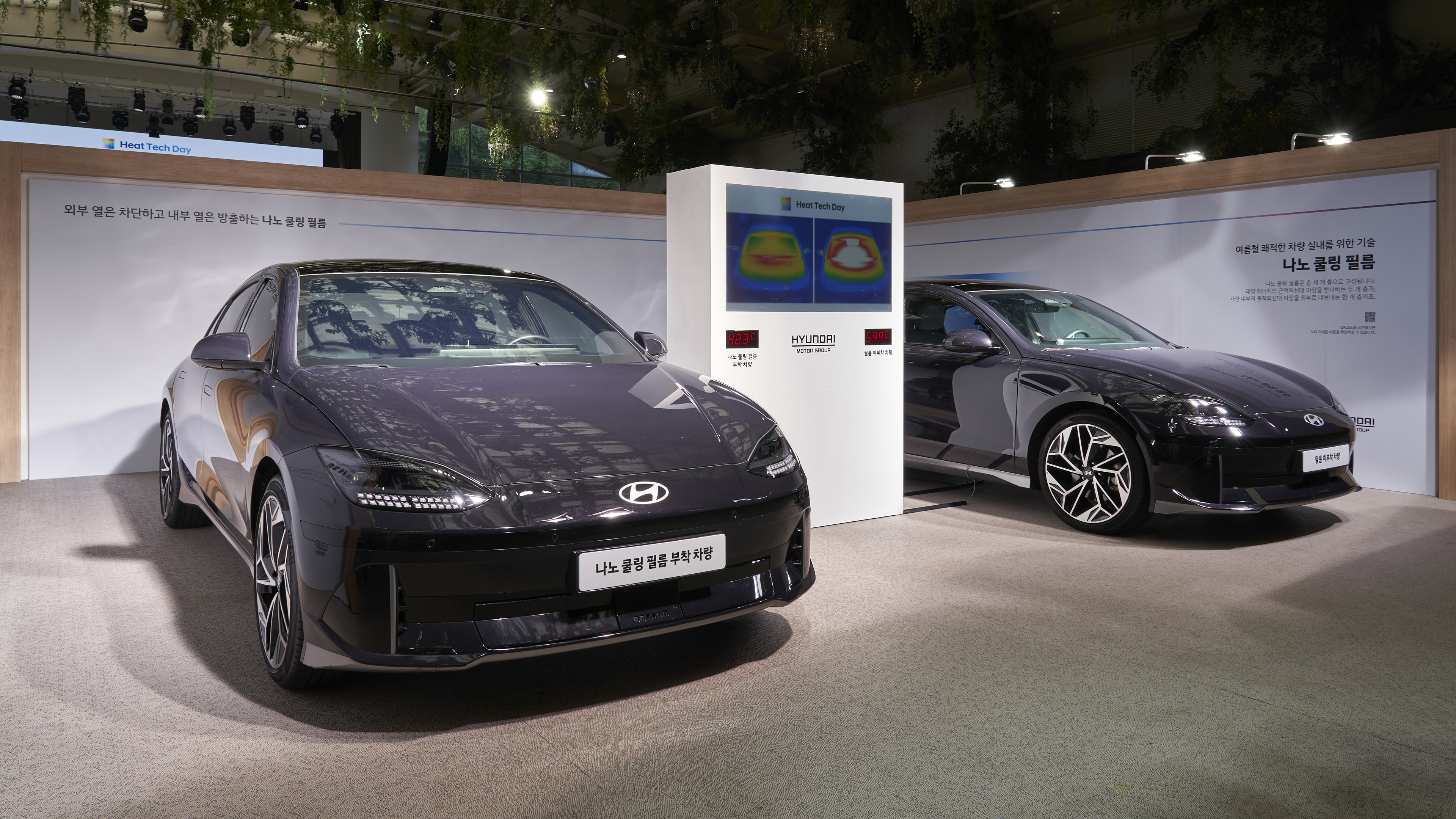 앞을 보고 서있는 두 대의 차량과 가운데 위치한 거대한 디스플레이