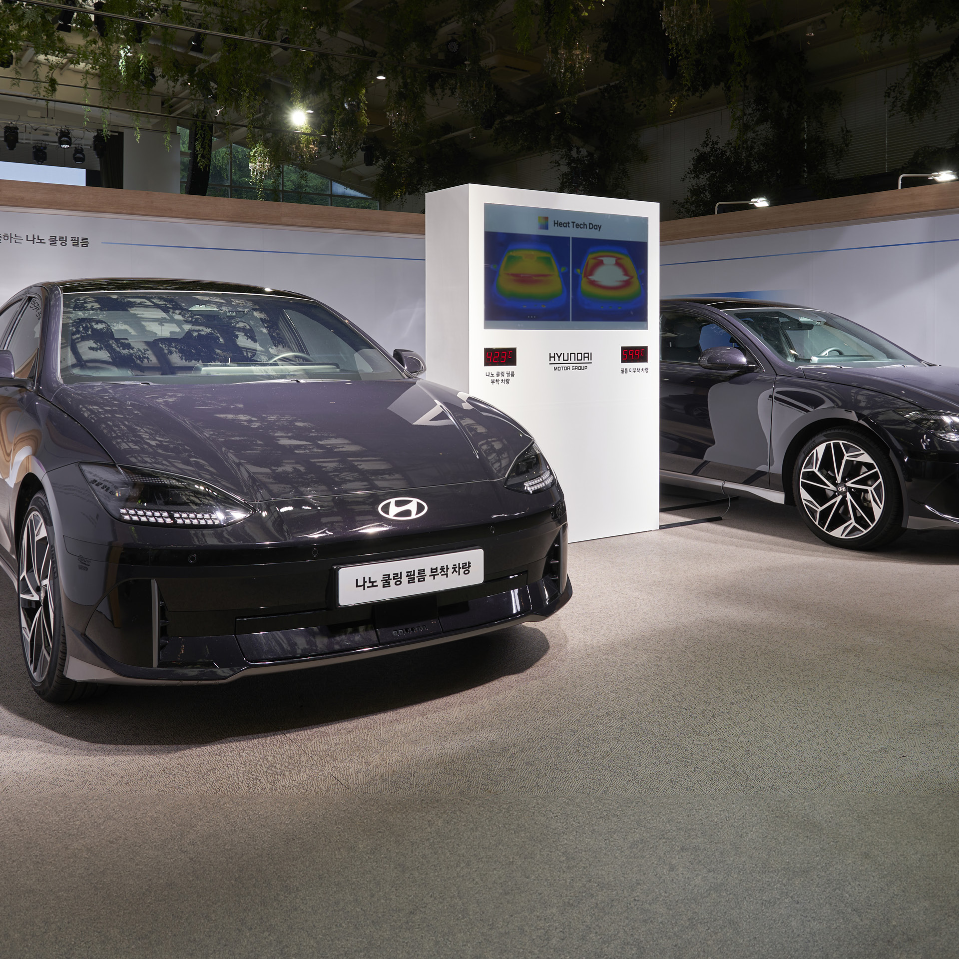 앞을 보고 서있는 두 대의 차량과 가운데 위치한 거대한 디스플레이
