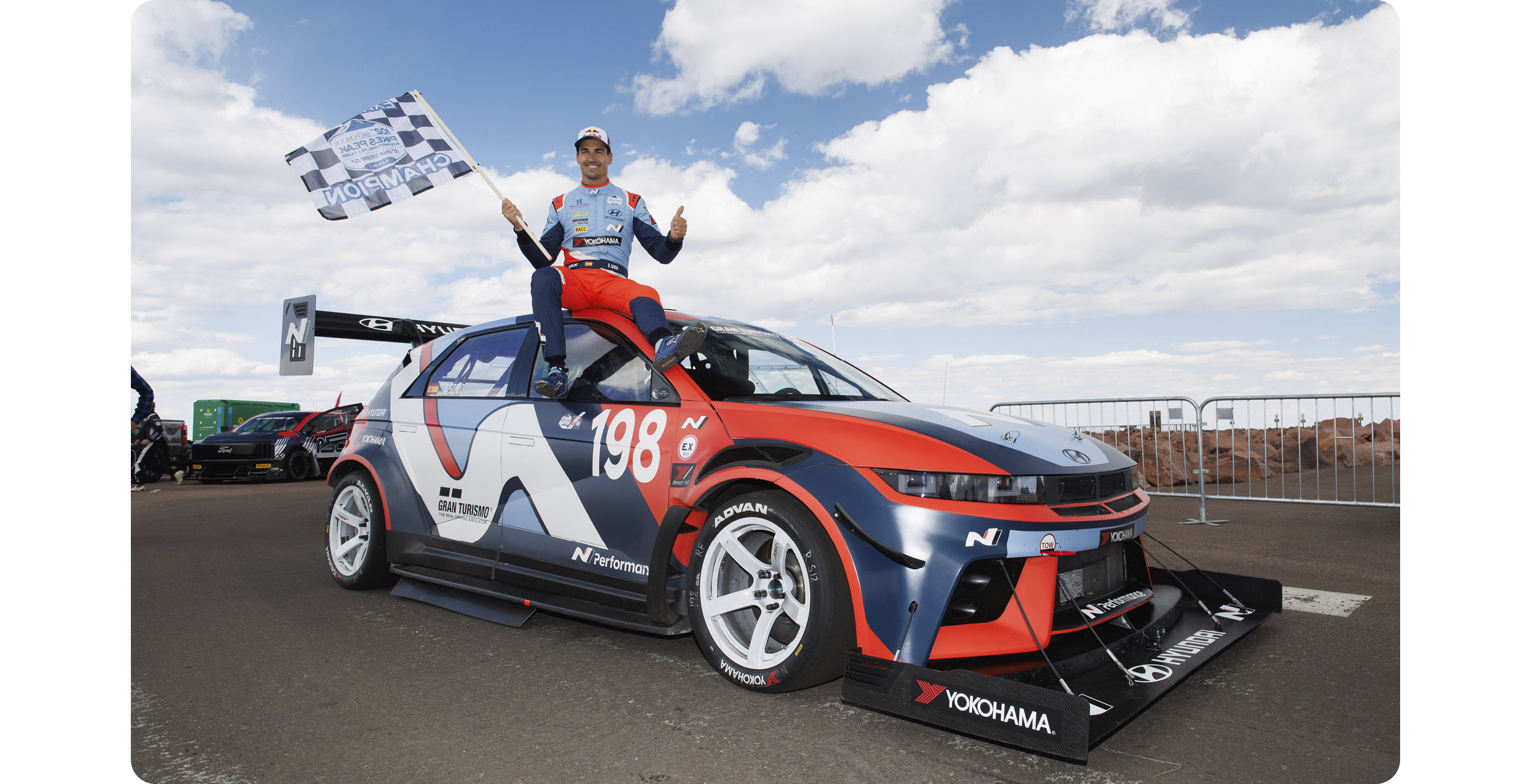 a driver who climbs on top of the vehicle and the vehicle and shakes the checker after winning the race