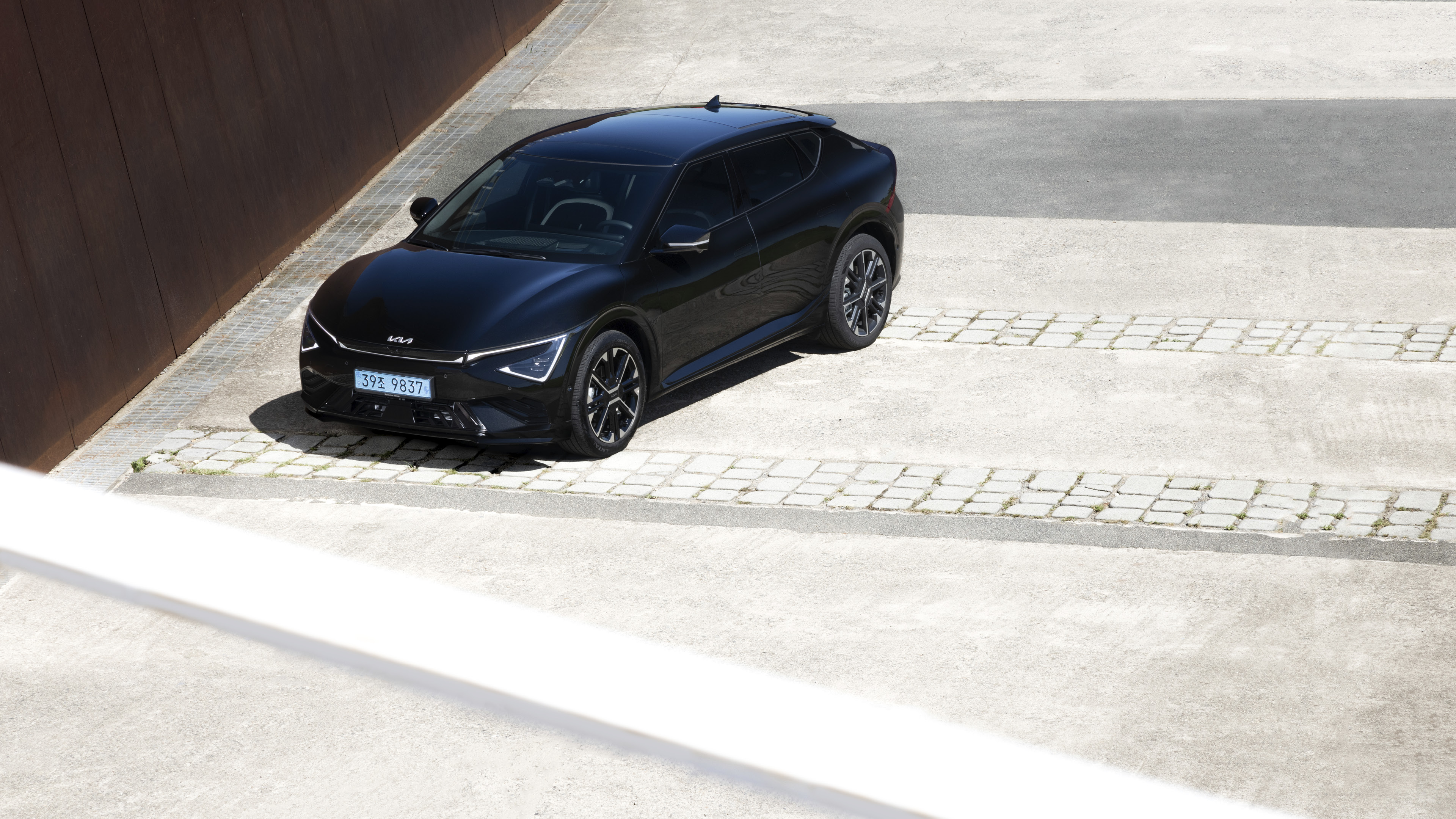 검은색 전기차가 하얀색 대지 위에 정차한 전측면 모습