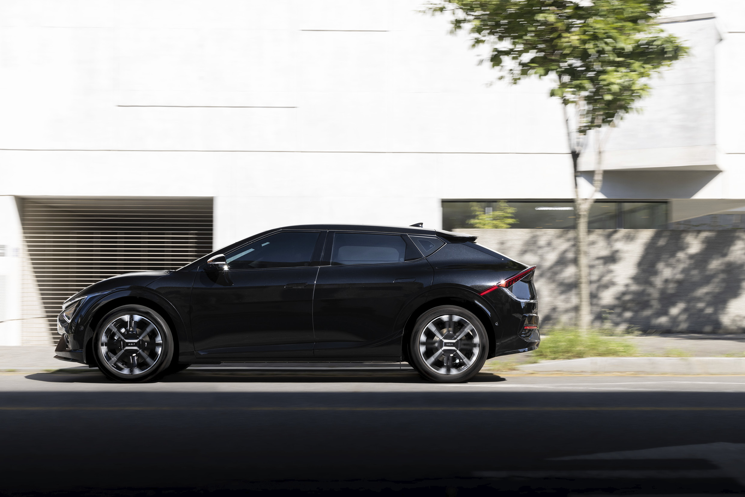 a front view of a black electric car driving through the city center