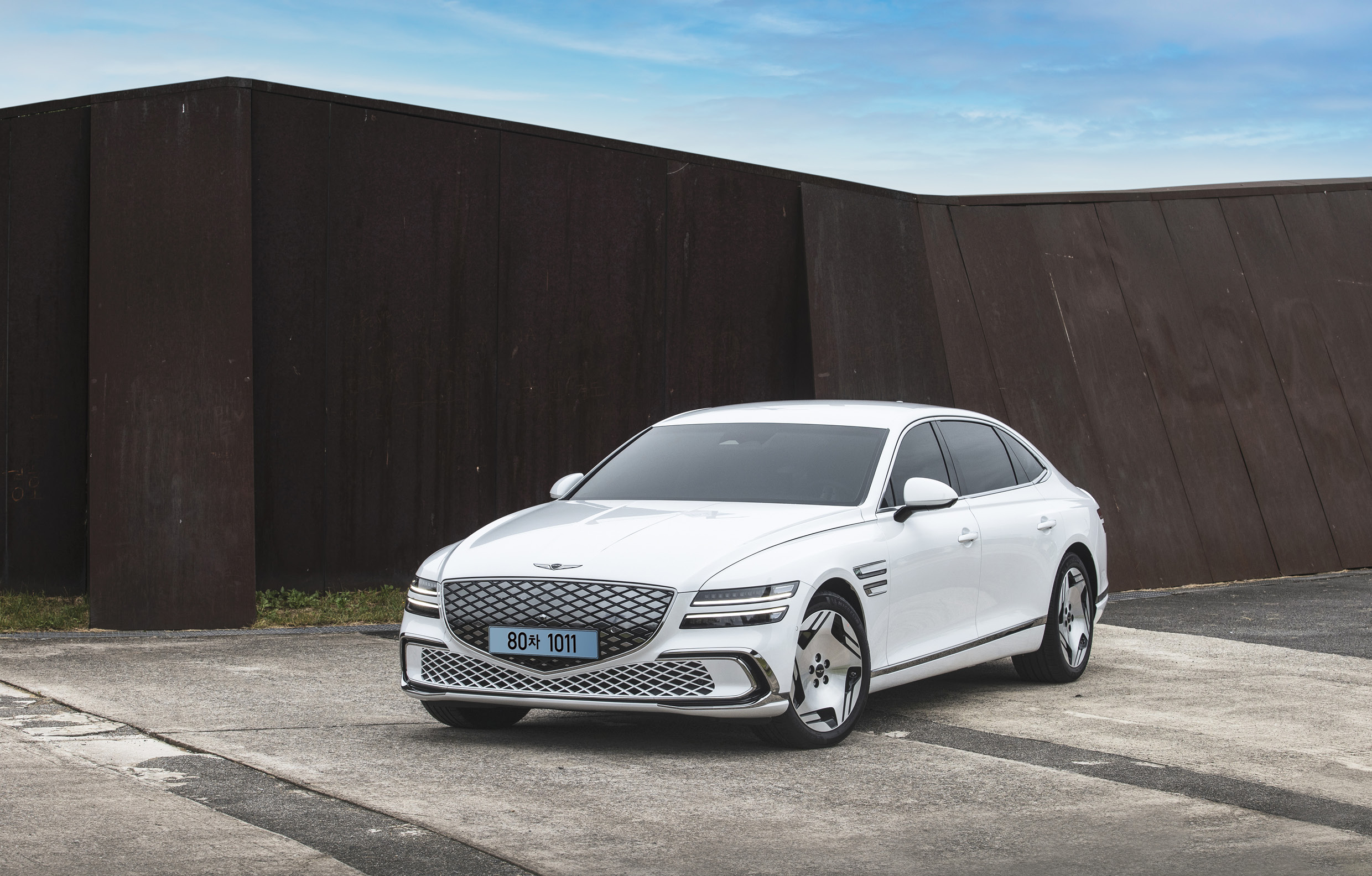 검은 조형물 배경으로 정차한 흰색 G80 전측면