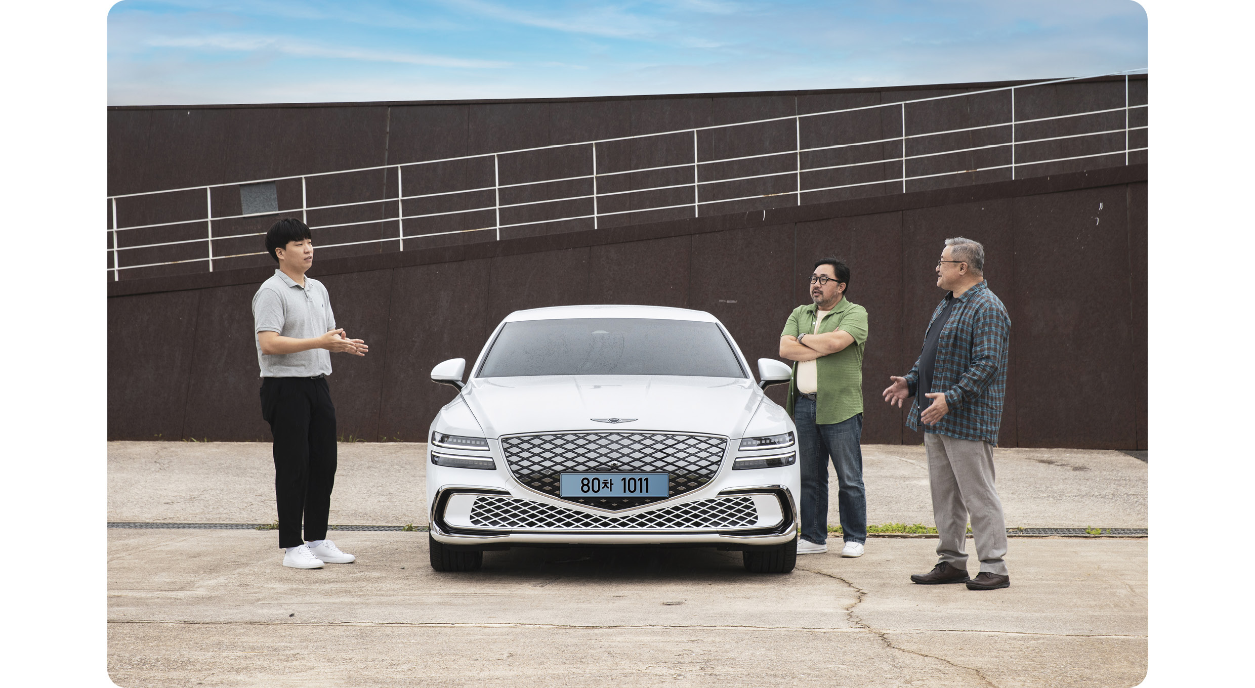 G80 주변에 남성 세 명이 모인 모습