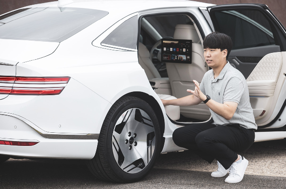 뒷좌석 옆에서 차량을 설명하는 남성의 모습