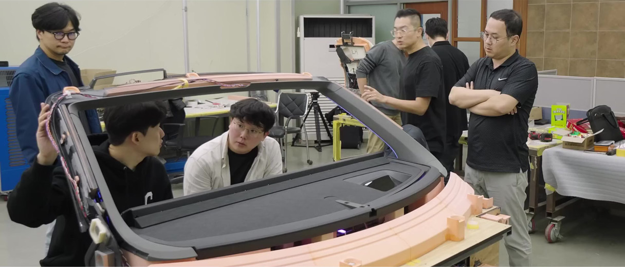 연구원 여러 명이 개발품 주변에 서 있는 모습