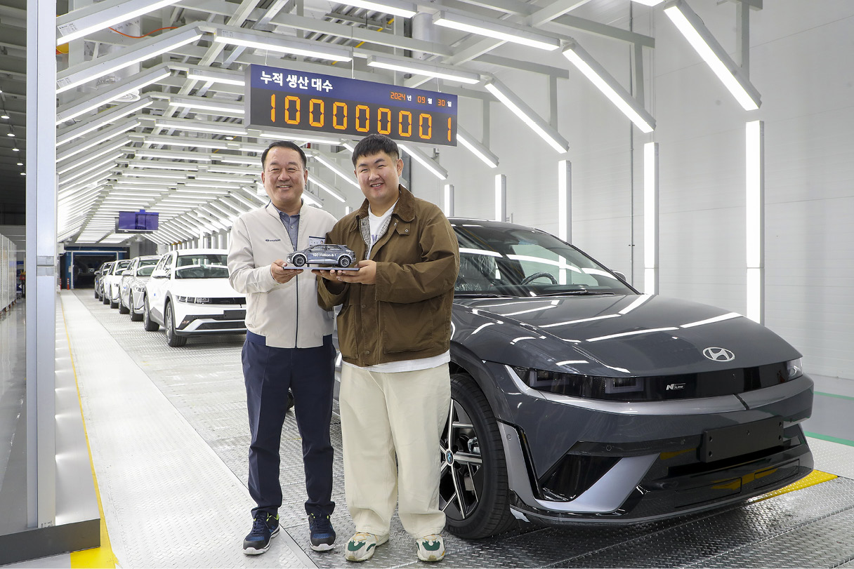 2 men posing for a commemorative pose at the factory