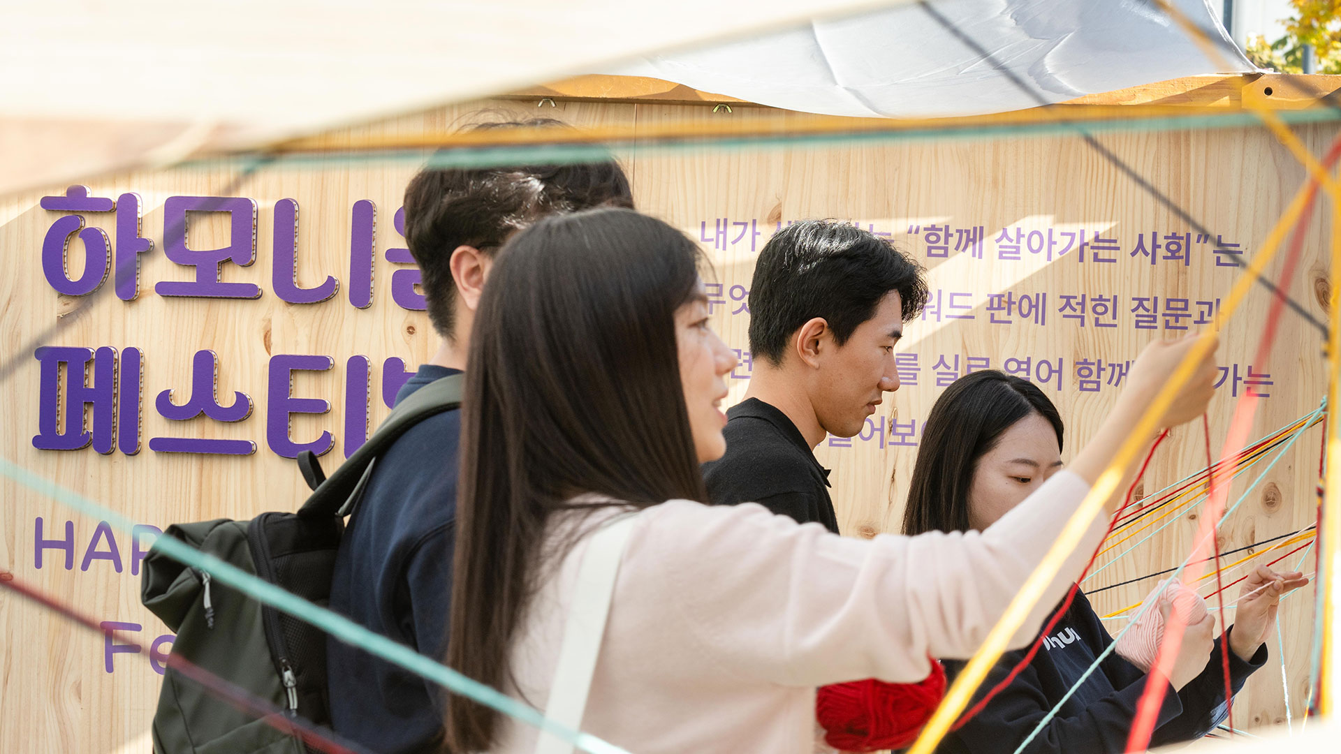 하모니움 페스티벌에 참여한 시민들이 다문화 사회에 필요한 가치를 털실로 연결하는 ‘키워드 아트월’을 체험하는 모습.