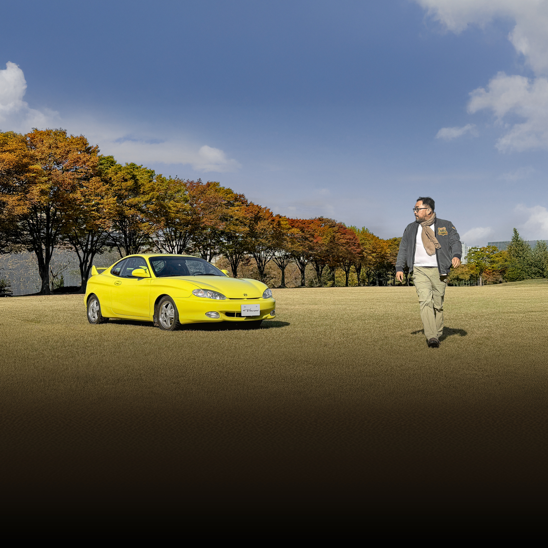 잔디밭 위에 남자가 티뷰론과 함께 포즈를 취한 모습