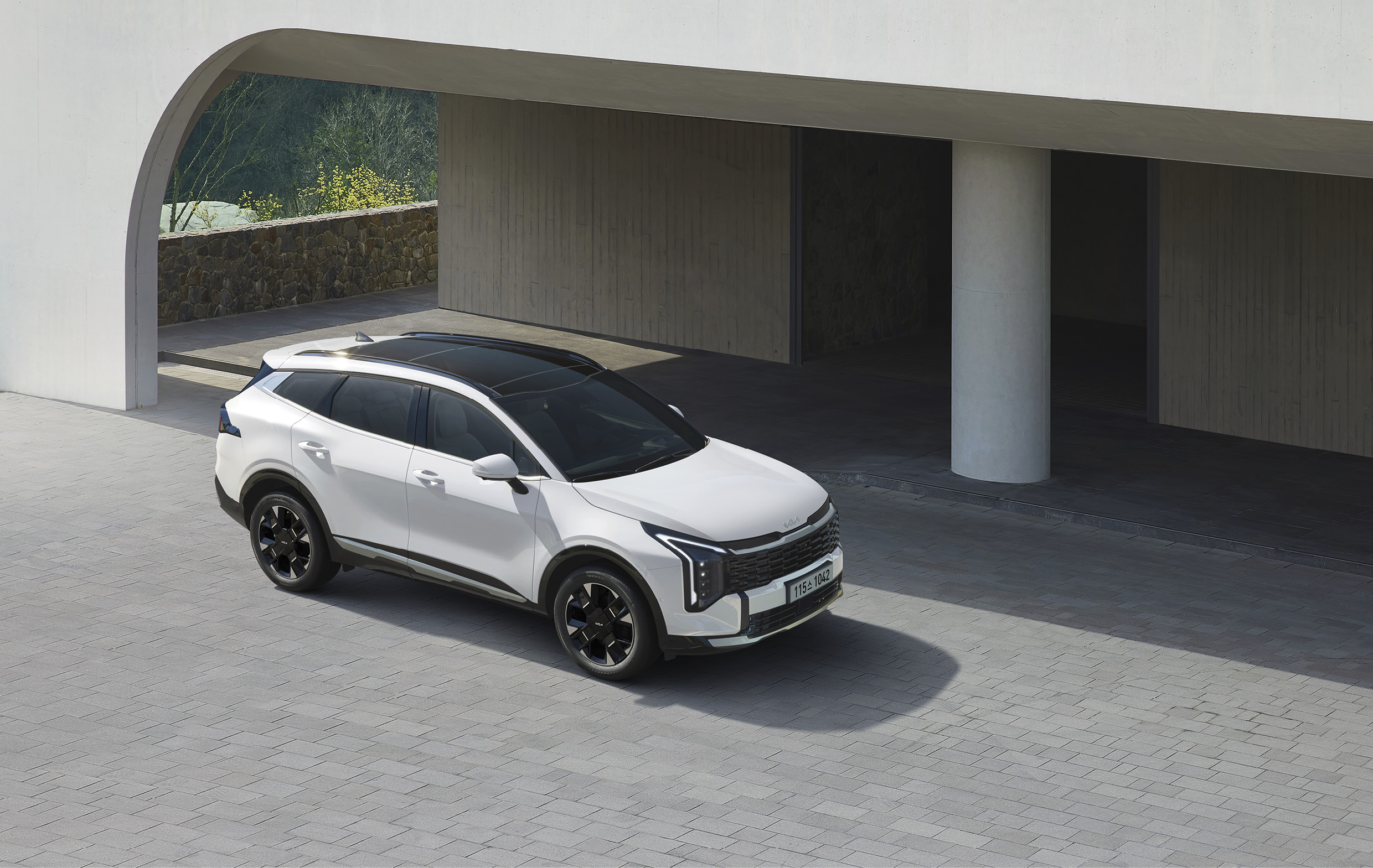 건물 앞에 정차한 스포티지 전측면 모습