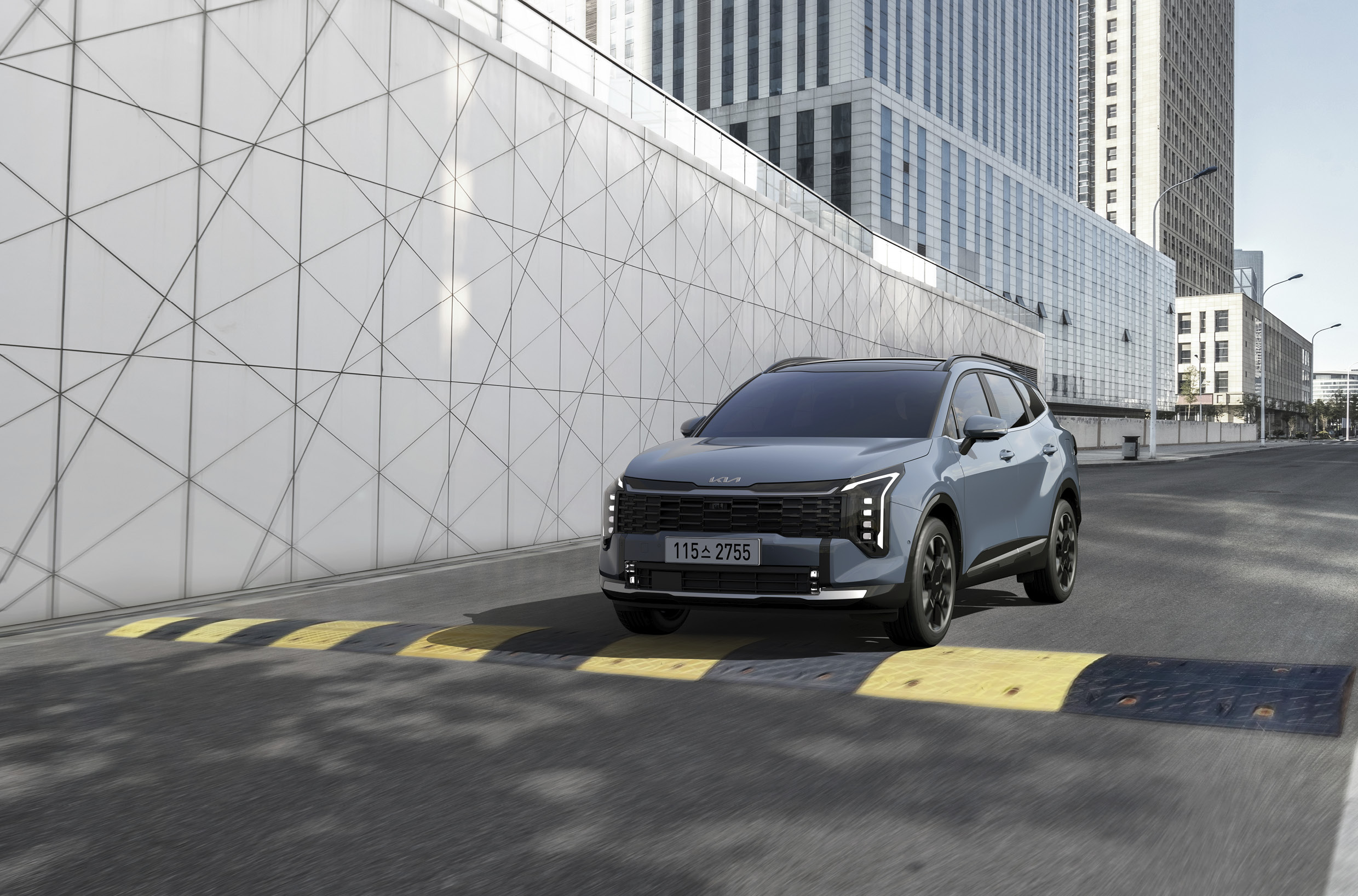 방지턱이 있는 도로를 주행하는 스포티지 전측면 모습