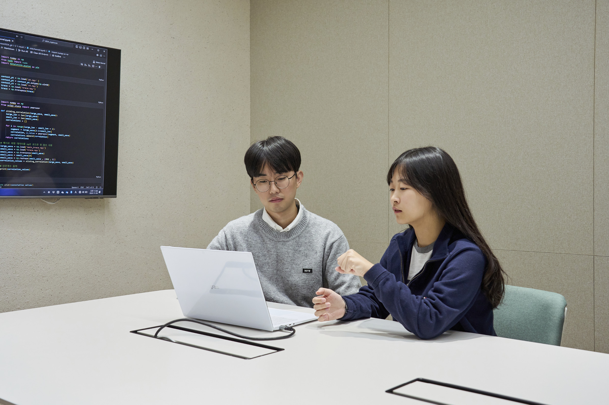 연구원 2명이 테이블 앞에 앉아 노트북 컴퓨터를 조작하는 모습