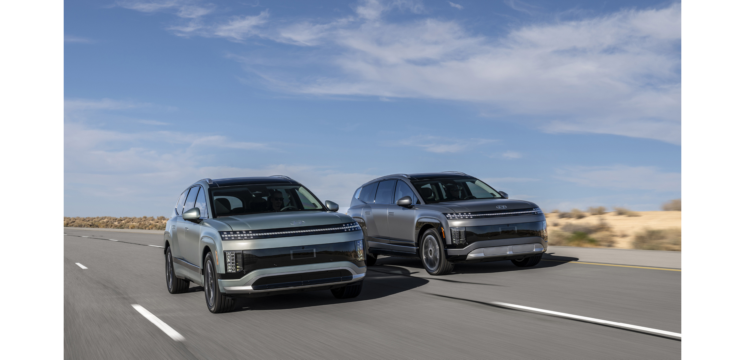 아이오닉 9 두 대가 아스팔트 도로 위를 나란히 주행하는 전측면 모습