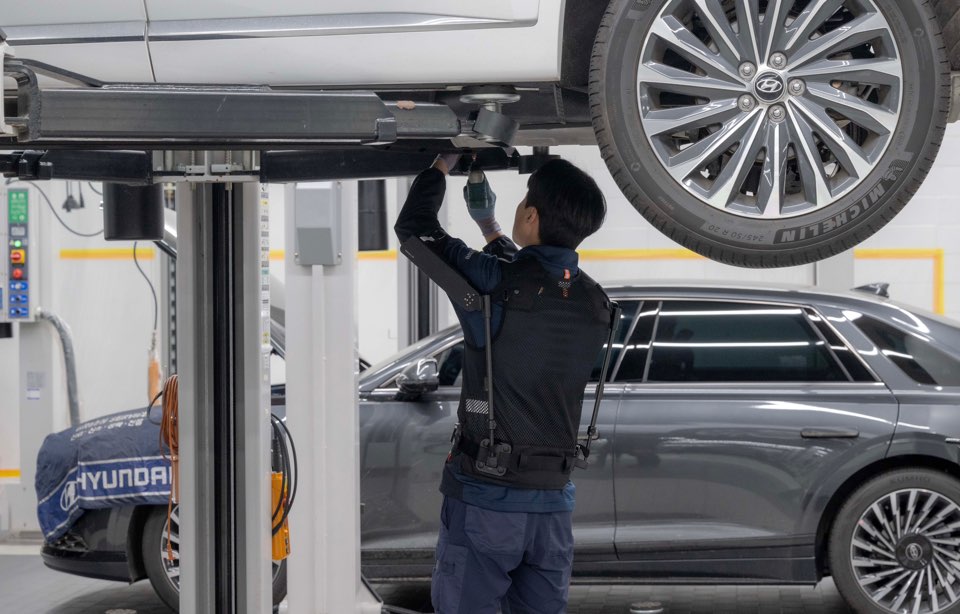 현대차 고양하이테크센터에서 작업자가 ‘엑스블 숄더’를 착용하고 차량 하부를 정비하는 모습