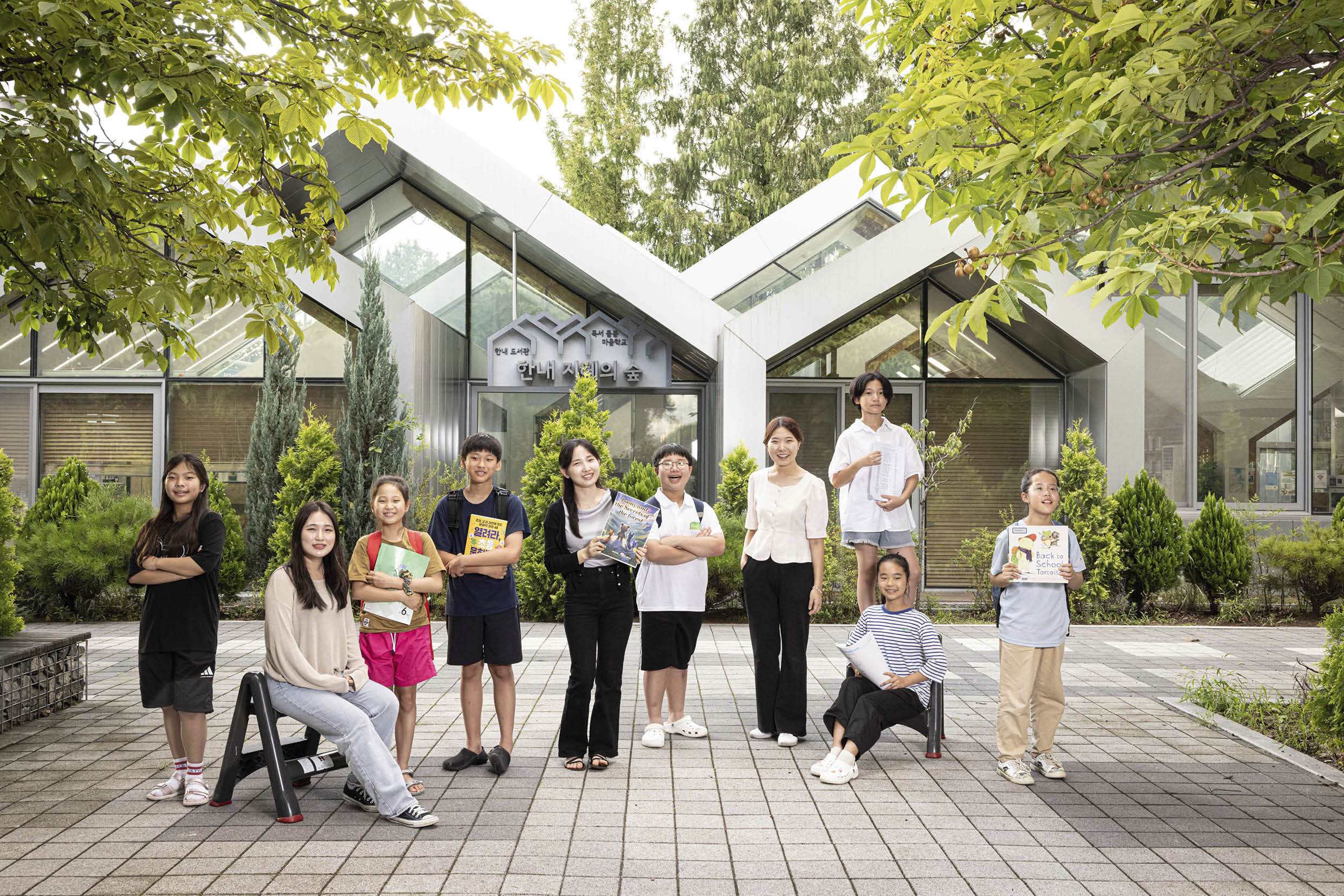 여러 명의 아이와 성인이 건물 앞에서 포즈를 취한 모습