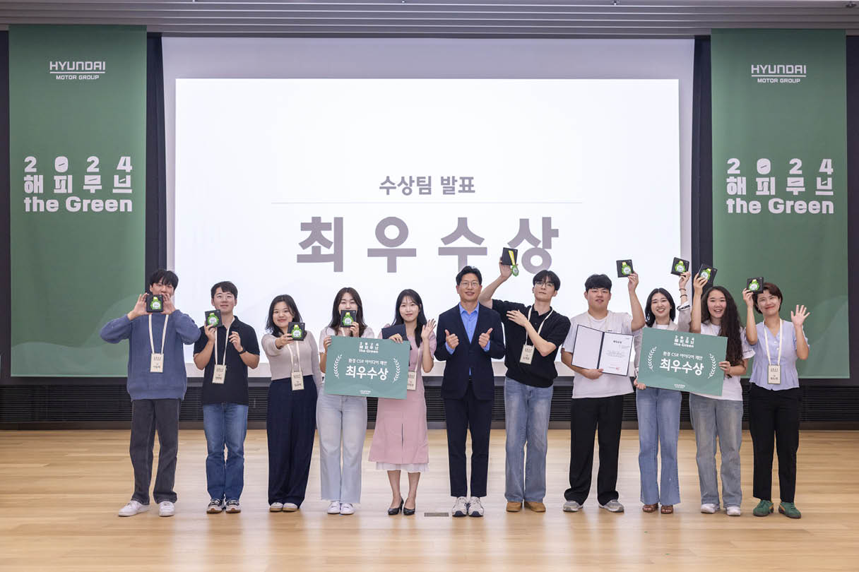 여러 명의 성인이 무대에서 수상 기념 포즈를 취한 모습