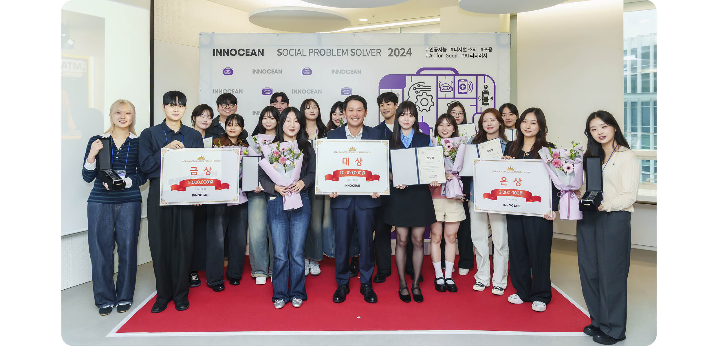 여러 명의 성인이 무대에서 수상 기념 포즈를 취한 모습