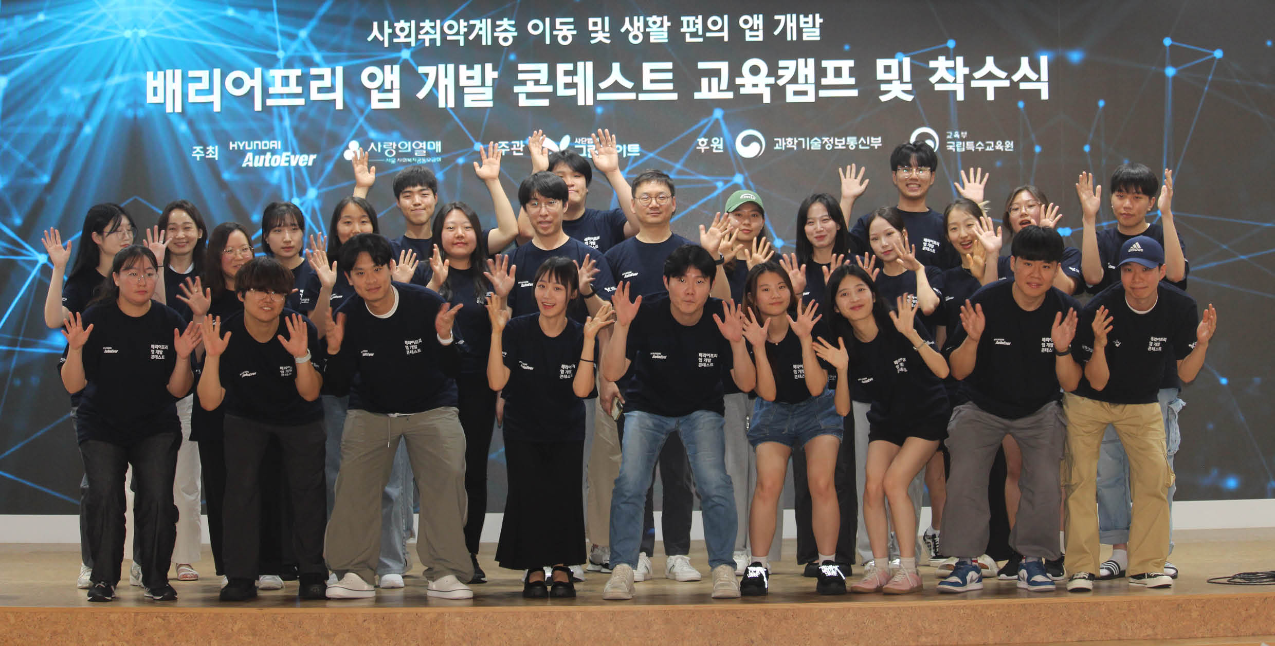 여러 명의 성인이 무대에서 수상 기념 포즈를 취한 모습