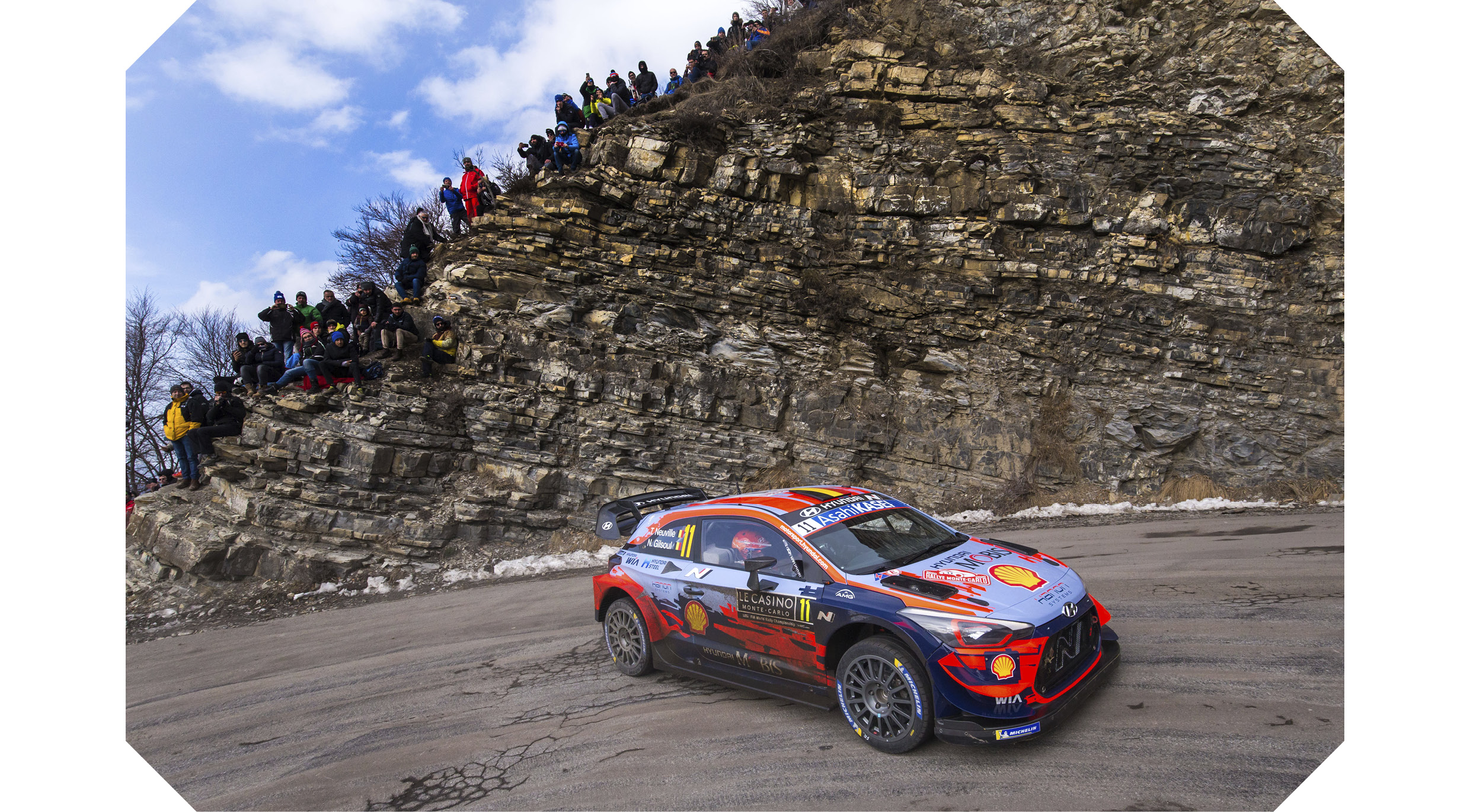 A rally car driving down a mountain path