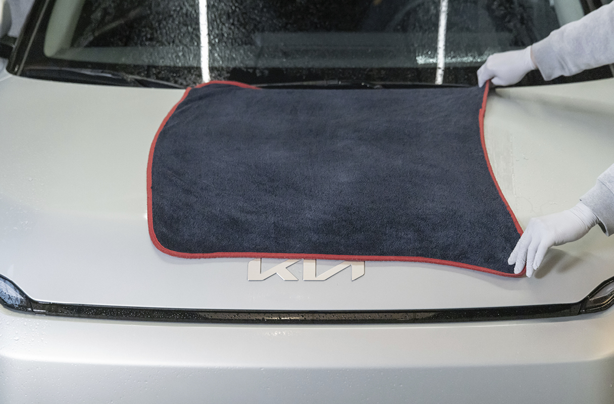 wiping the water off a car with a towel