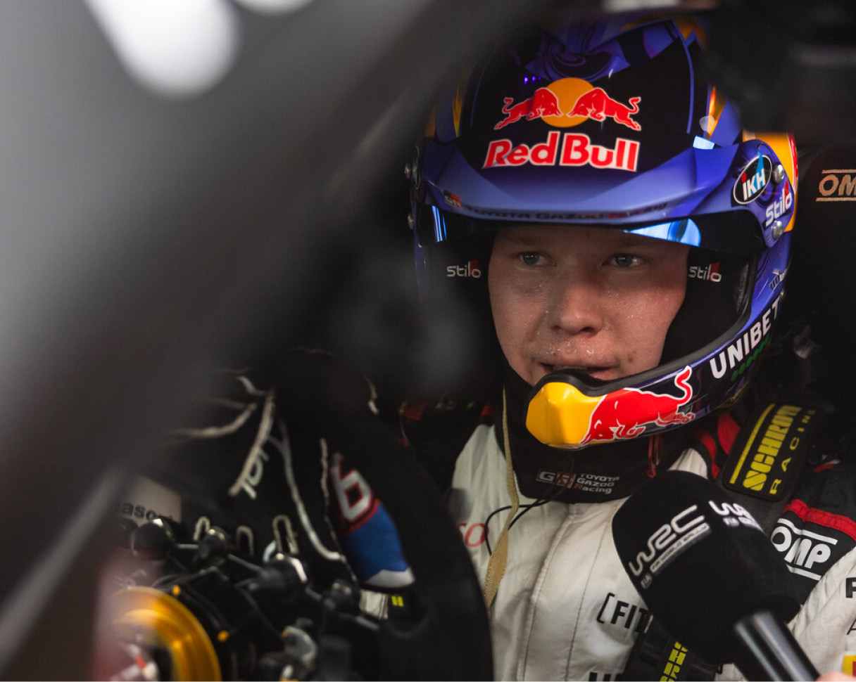 The rally driver is in the car and staring straight ahead
