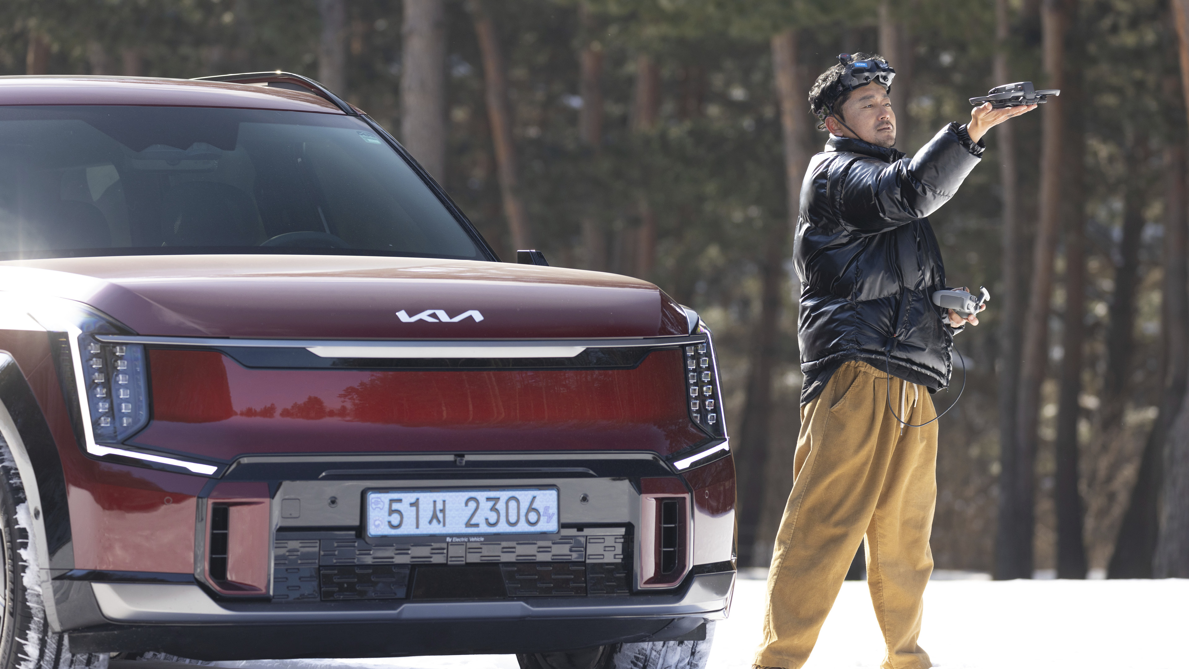 Kia EV9 and drone cinematographer stand in the snow
