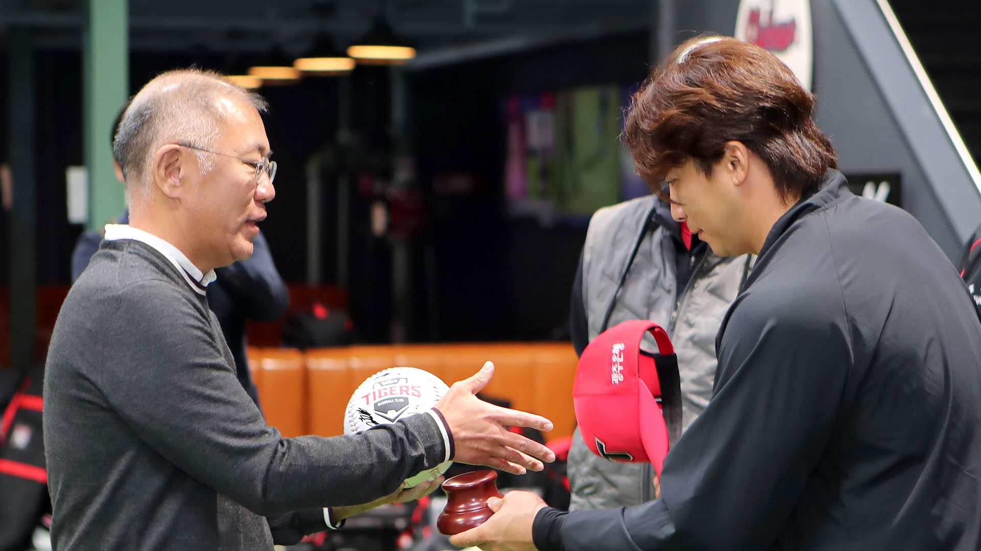 정의선 회장(왼쪽)이 주장 나성범 선수로부터 사인볼을 받고 악수하는 모습