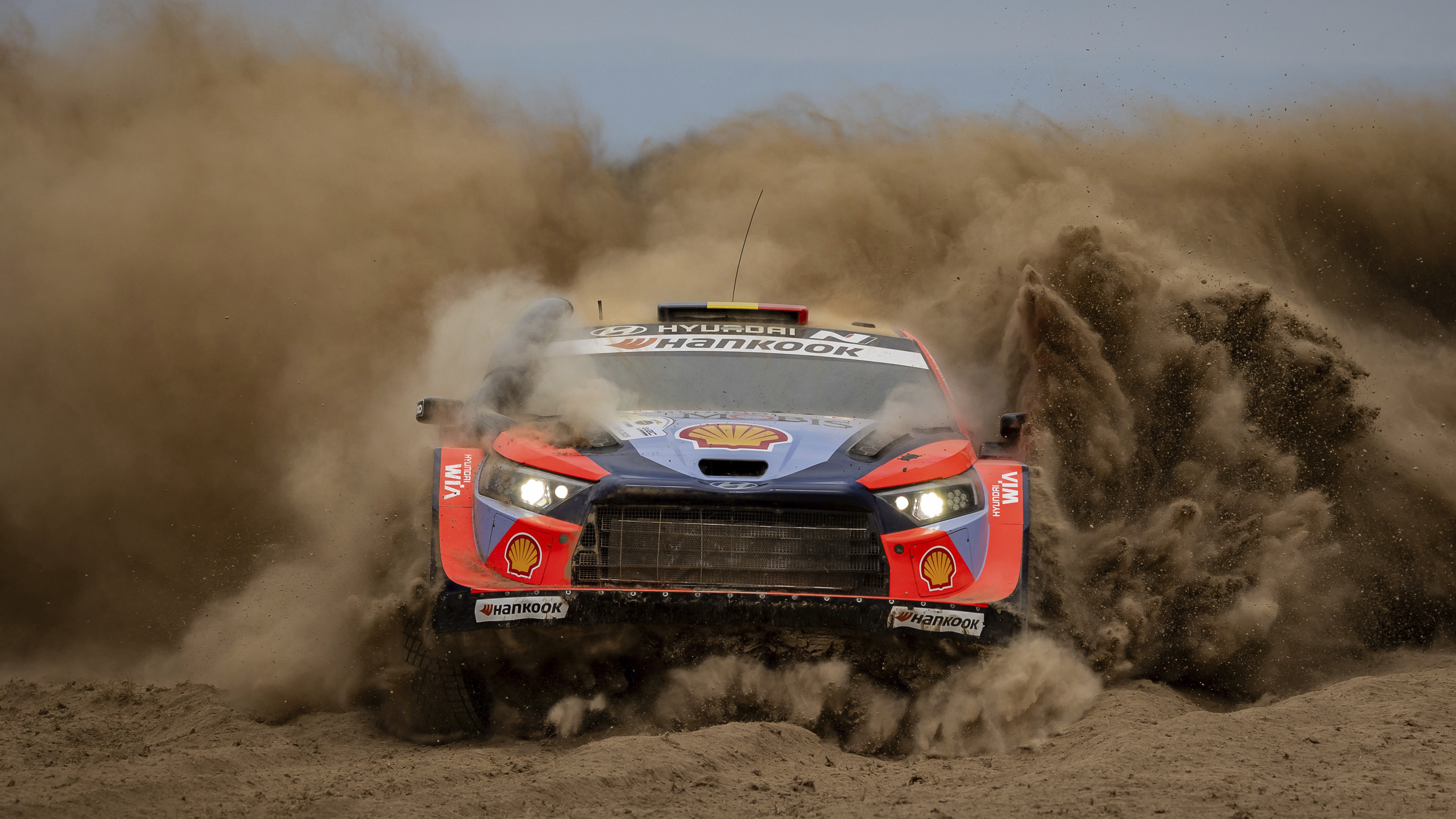 a rally car speeding through the dust