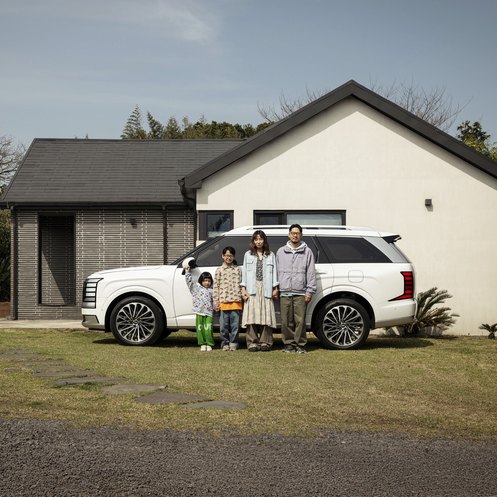 팰리세이드와 함께 서 있는 가족들의 모습