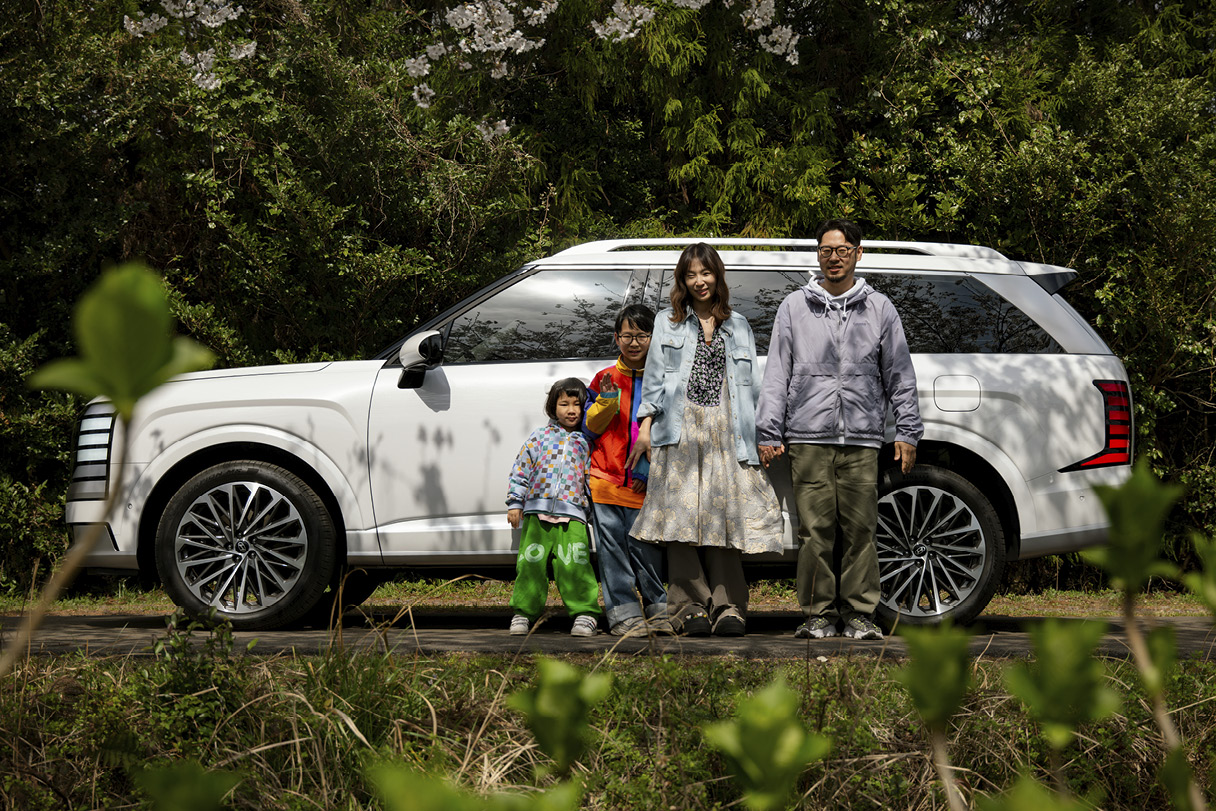 팰리세이드와 함께 서 있는 가족들의 모습