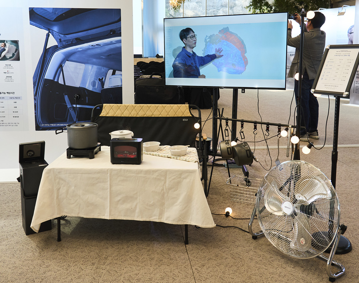 현대차그룹 차세대 하이브리드 시스템 테크데이에 전시된 하이브리드 차량의 V2L을 활용한 전자기기 사용 모습