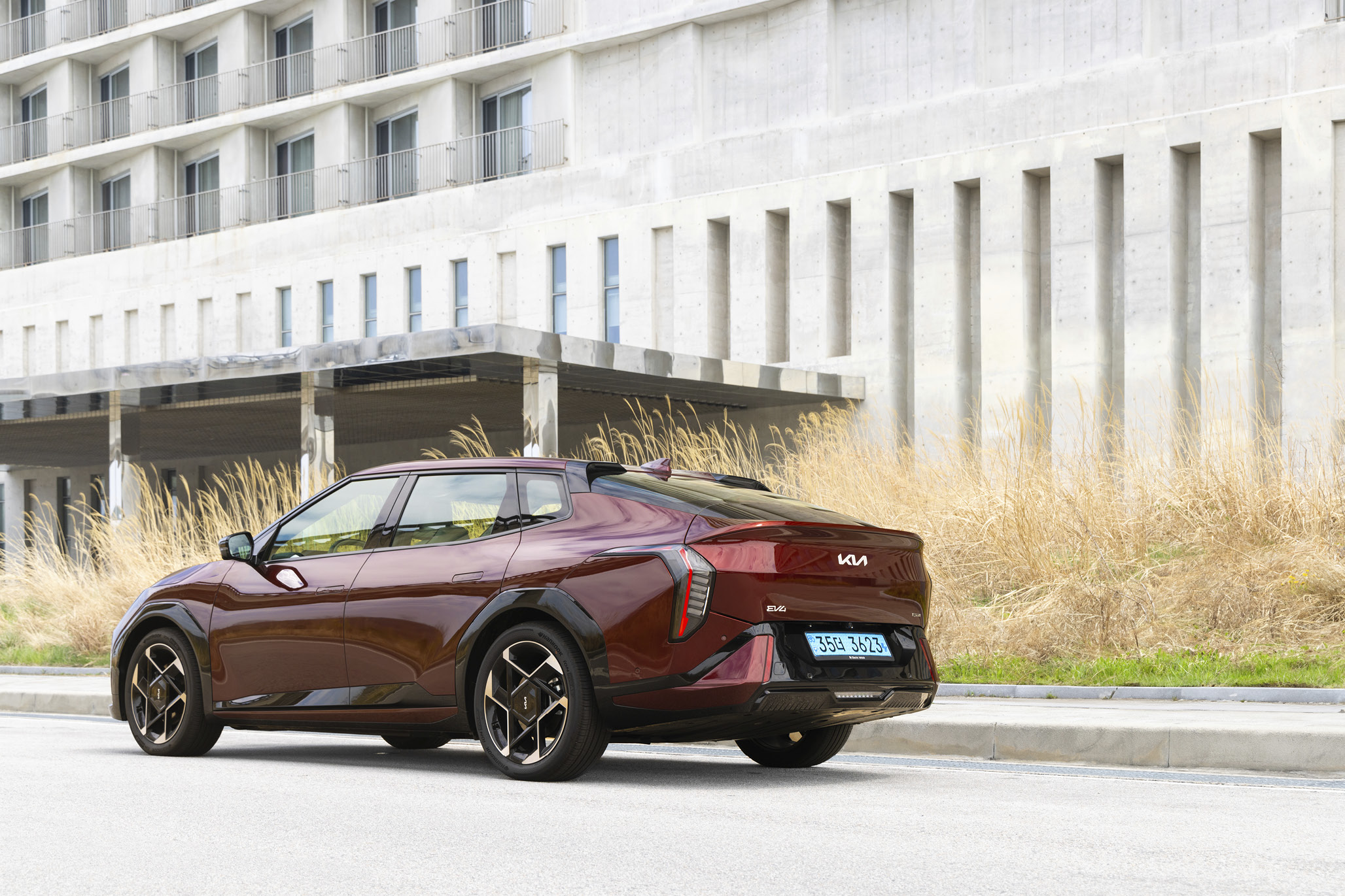 회색 건물 앞에 정차한 EV4 후측면 모습