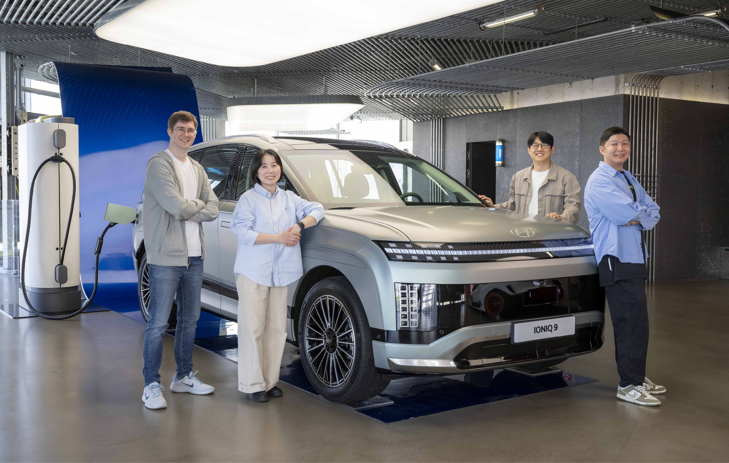 현대차 아이오닉 9과 UX 라이터 연구원들이 함께 서 있다