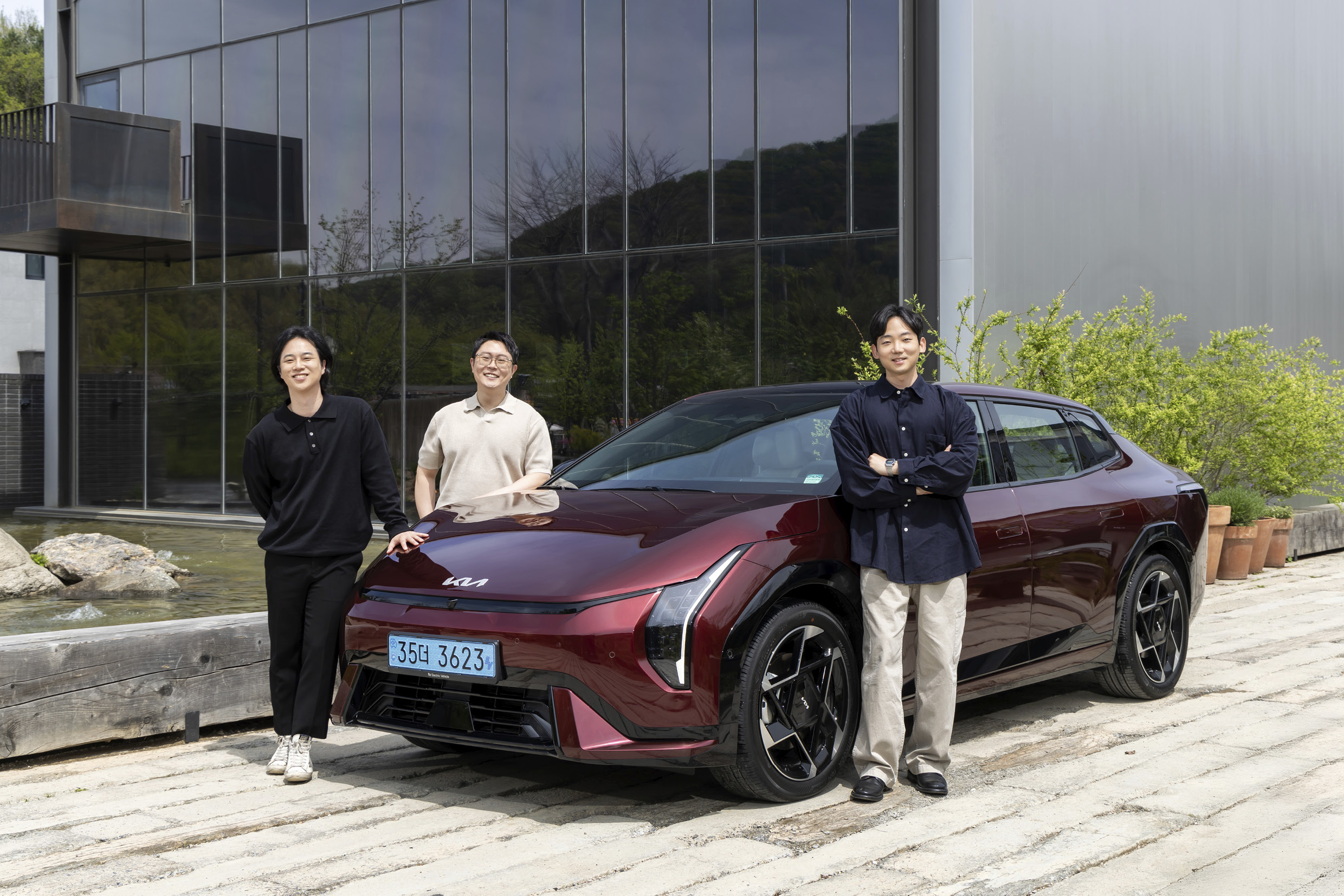 기아 EV4와 연구원이 같이 서 있는 모습