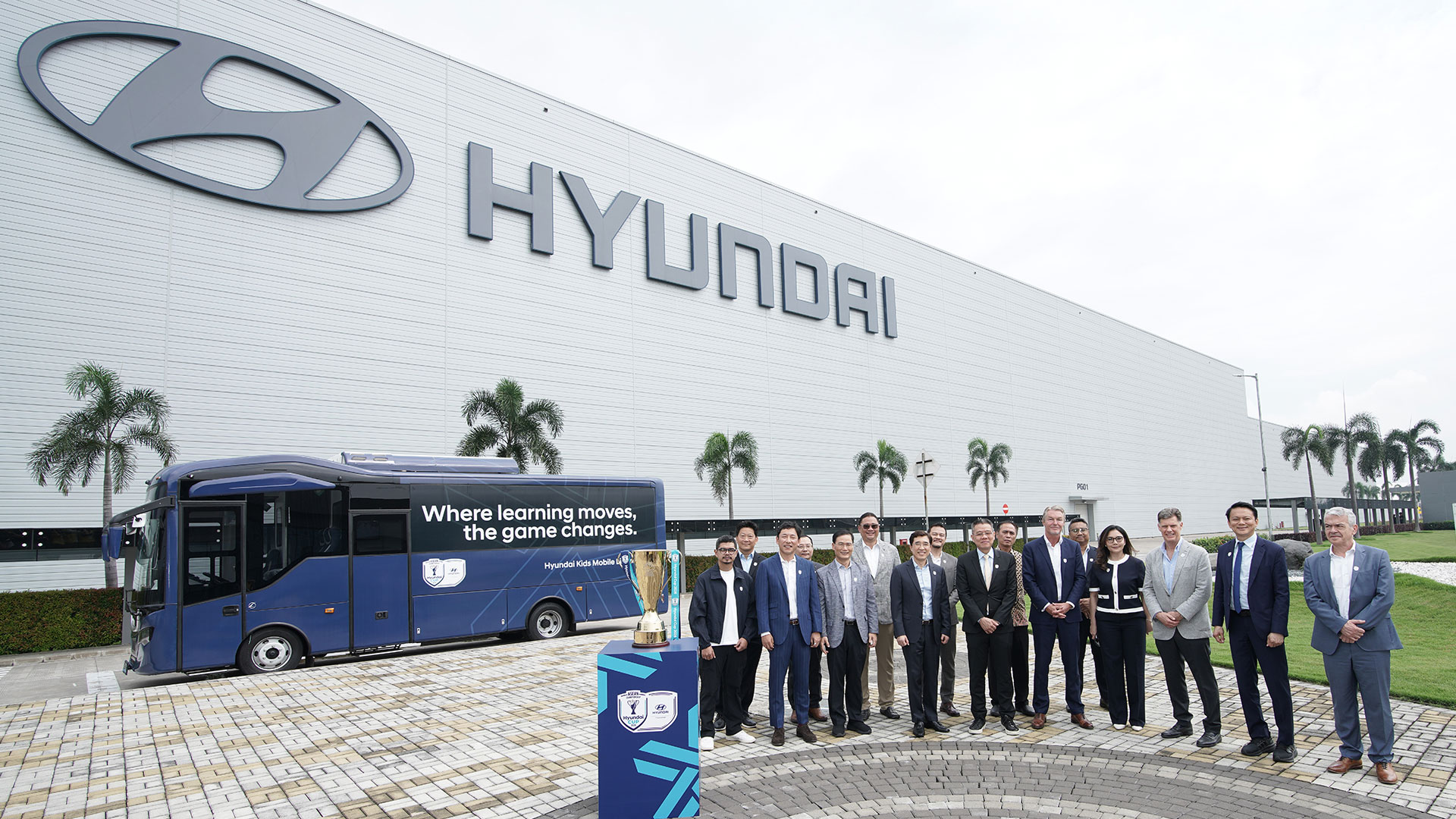 조인식 행사에 참석한 주요 관계자들이 현대자동차 인도네시아 공장(Hyundai Motor Manufacturing Indonesia, HMMI)과 EV 버스를 배경으로 기념촬영 하는 모습